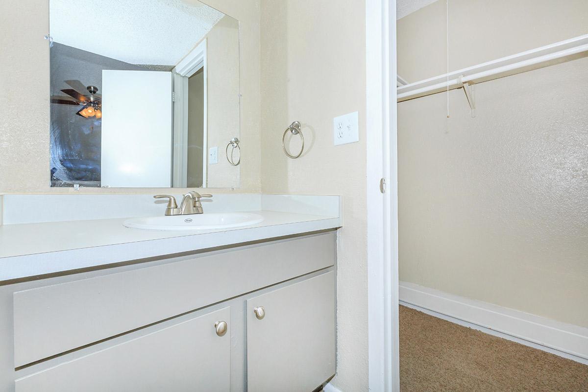 a white sink sitting under a mirror