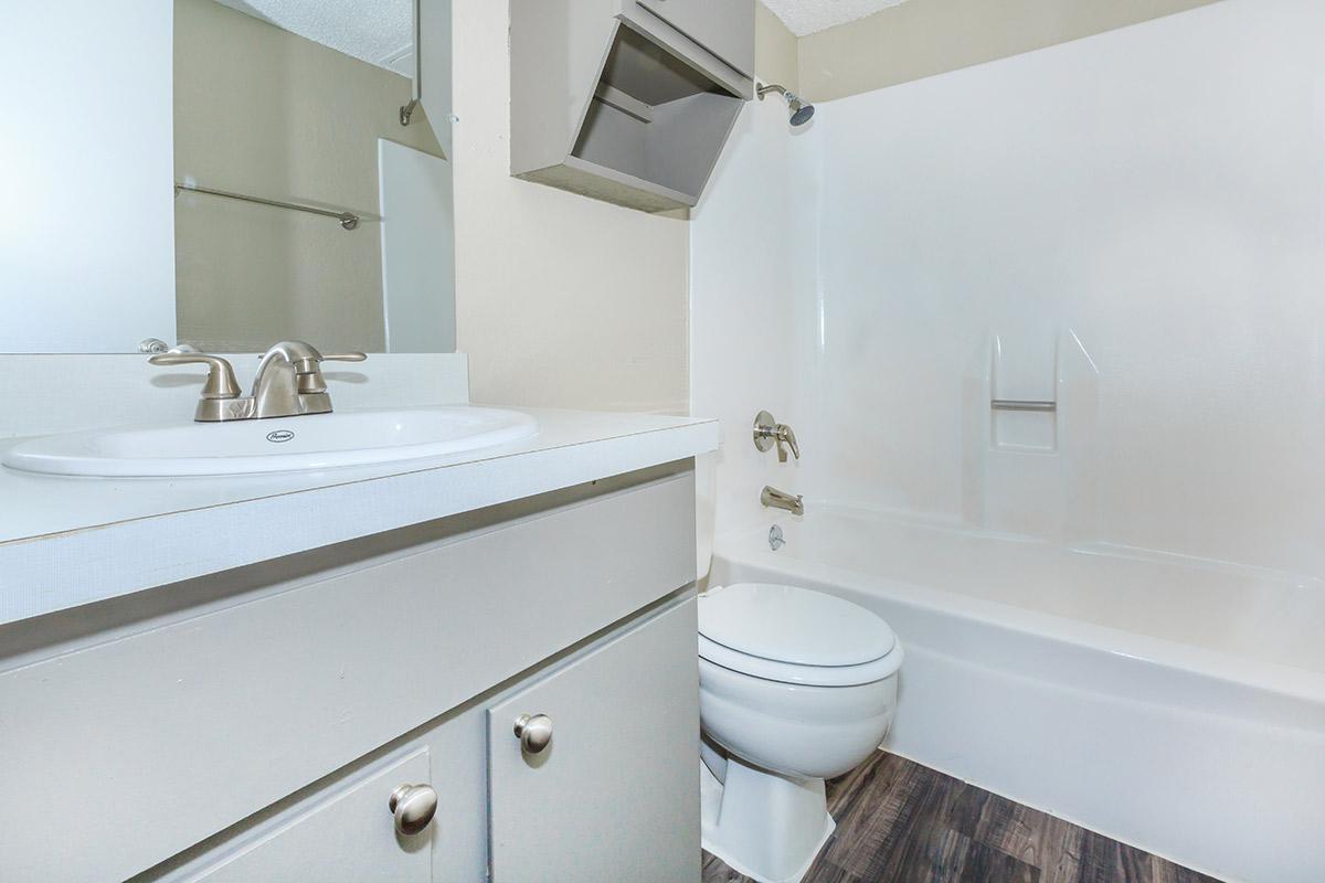 a white sink sitting next to a shower