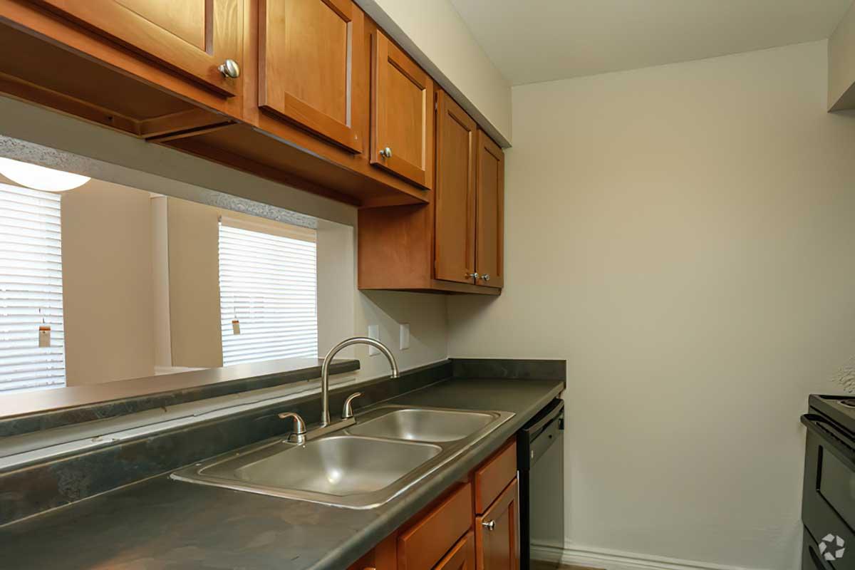 a kitchen with a stove a sink and a window