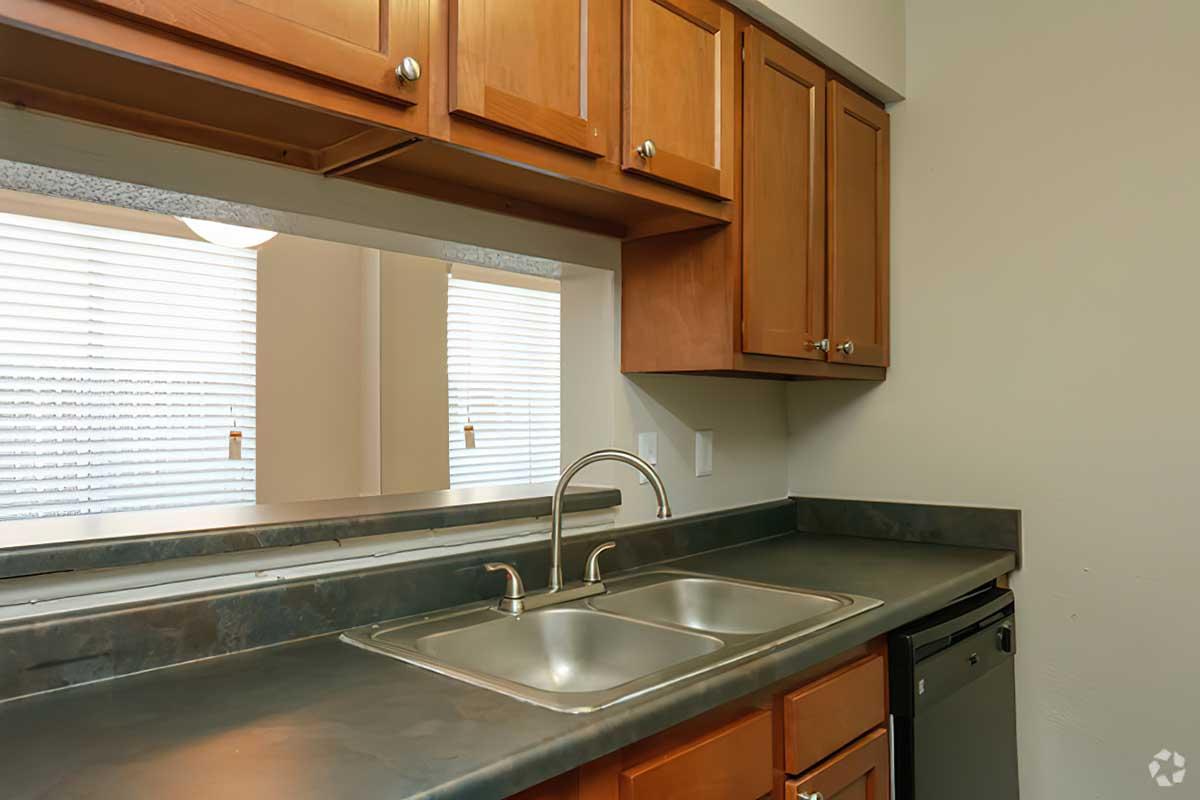 a kitchen with a stove a sink and a window