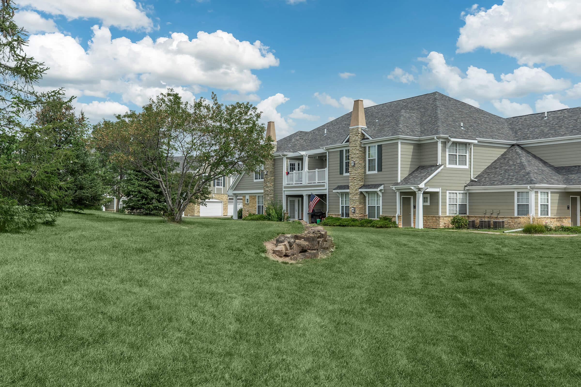 a large green field in front of a house