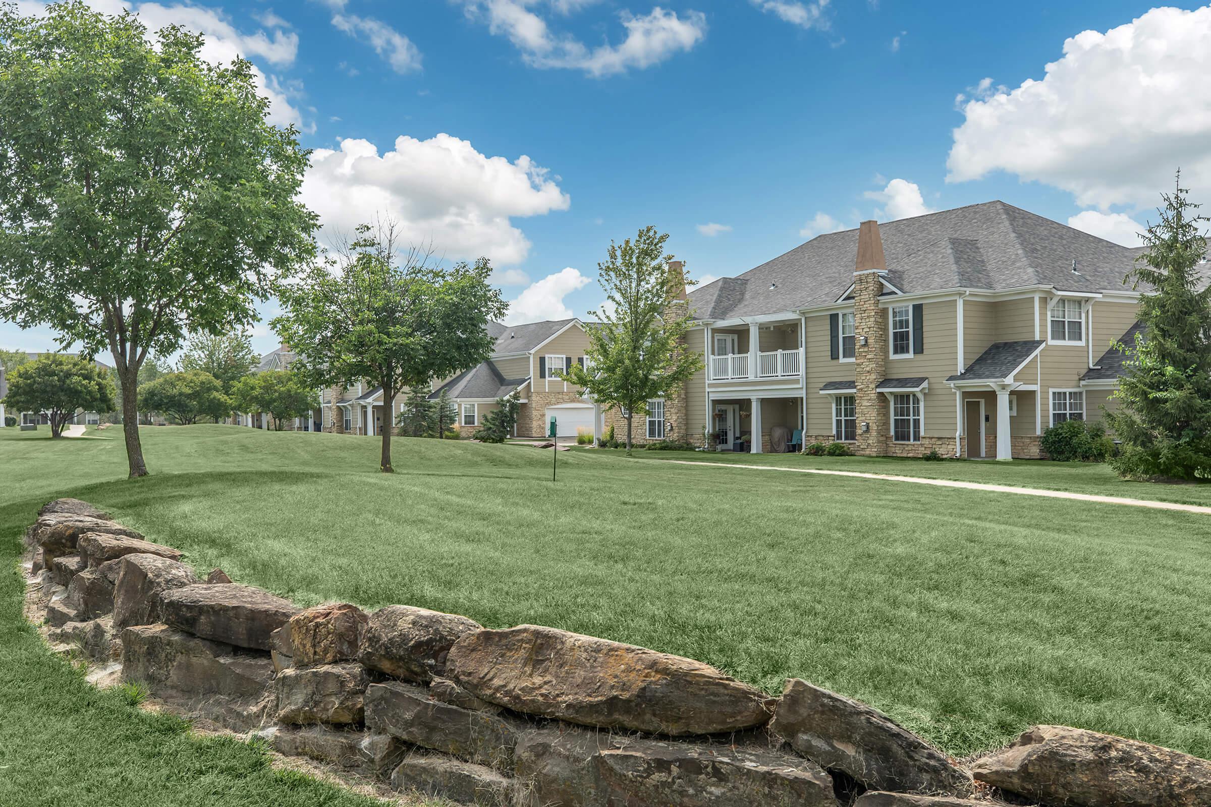 a large stone building with a grassy field