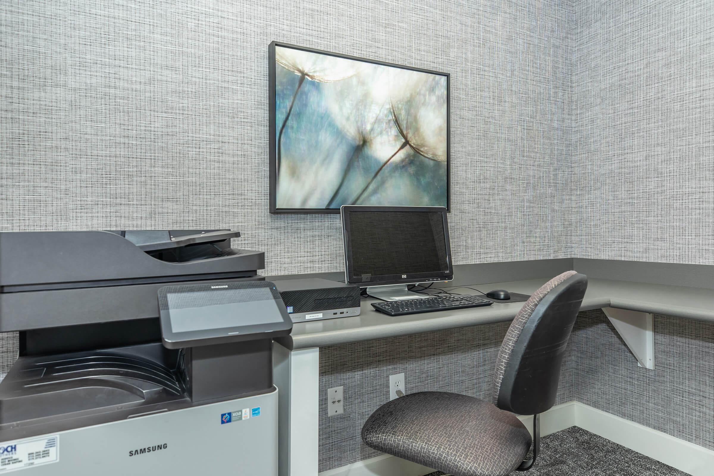 a desk with a laptop computer sitting on top of a chair