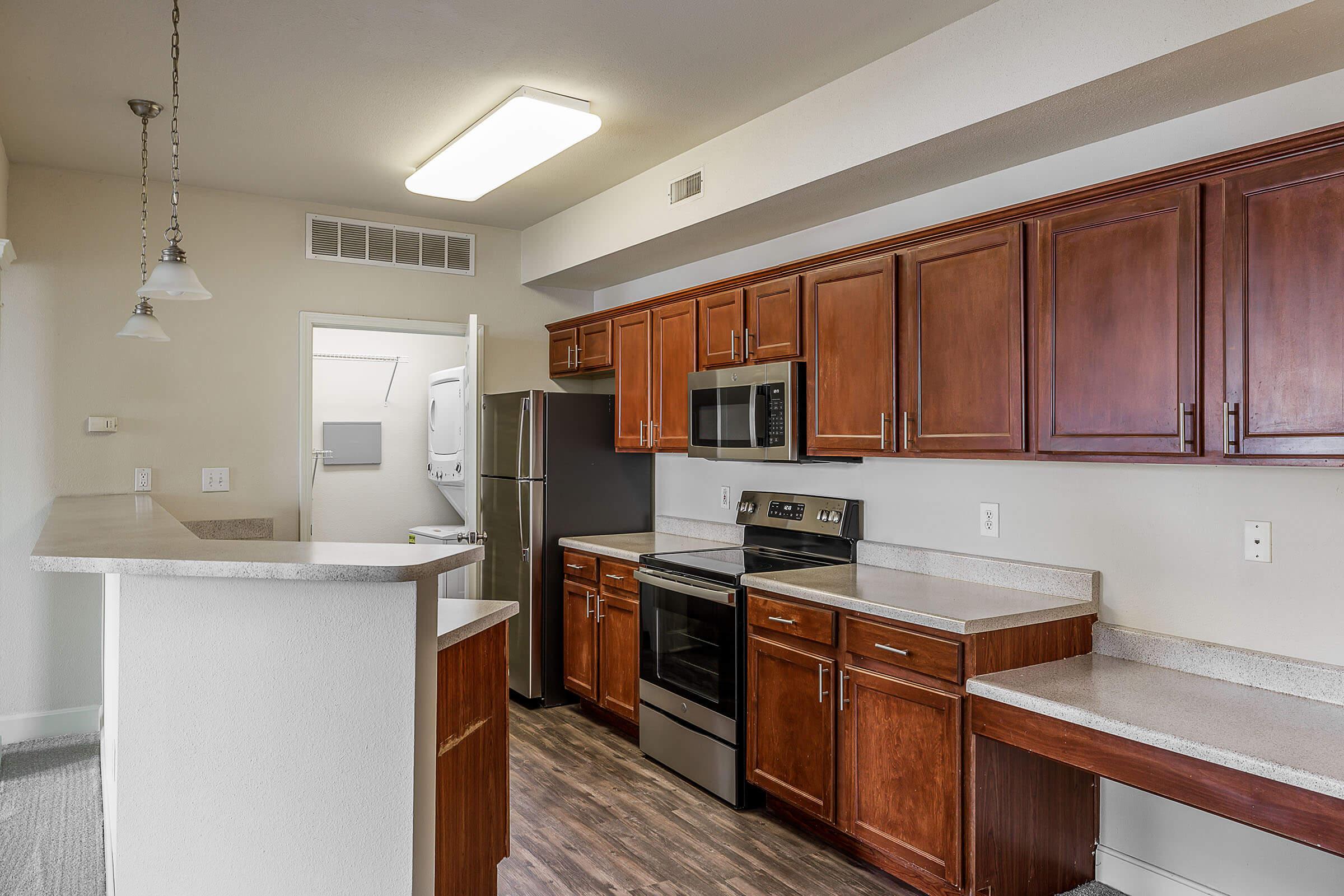 a modern kitchen with stainless steel appliances and wooden cabinets