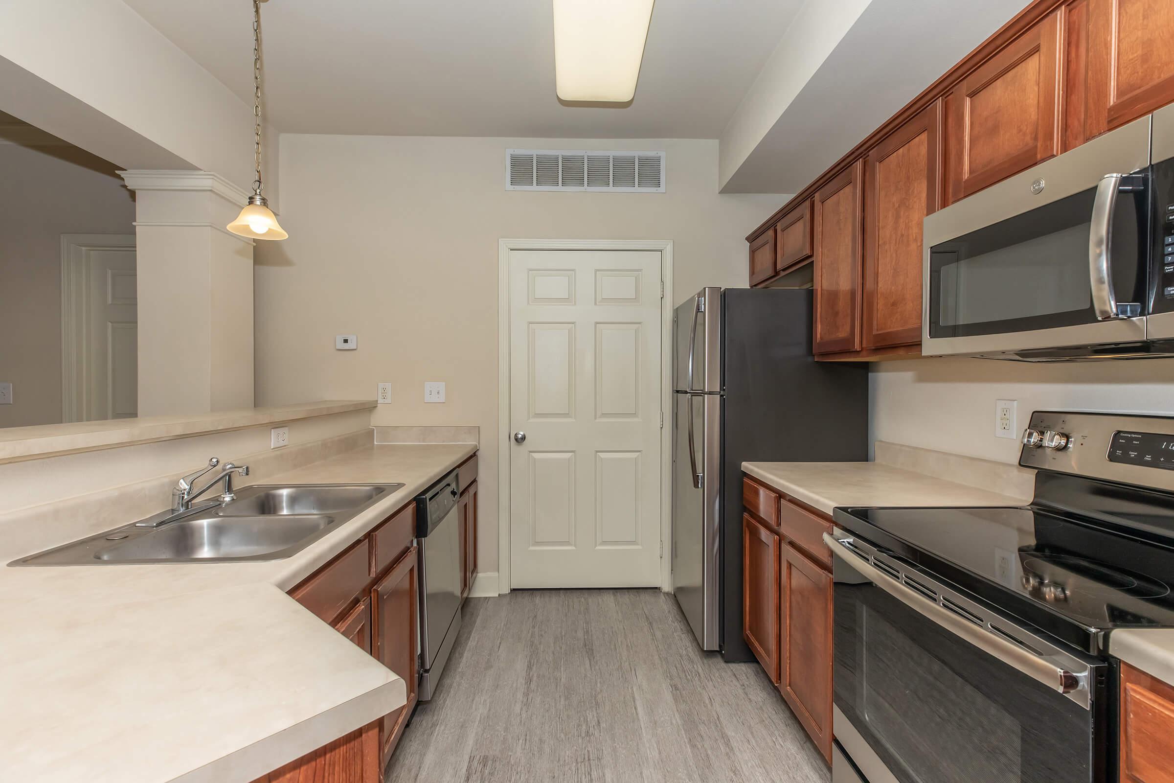 a large kitchen with stainless steel appliances and wooden cabinets