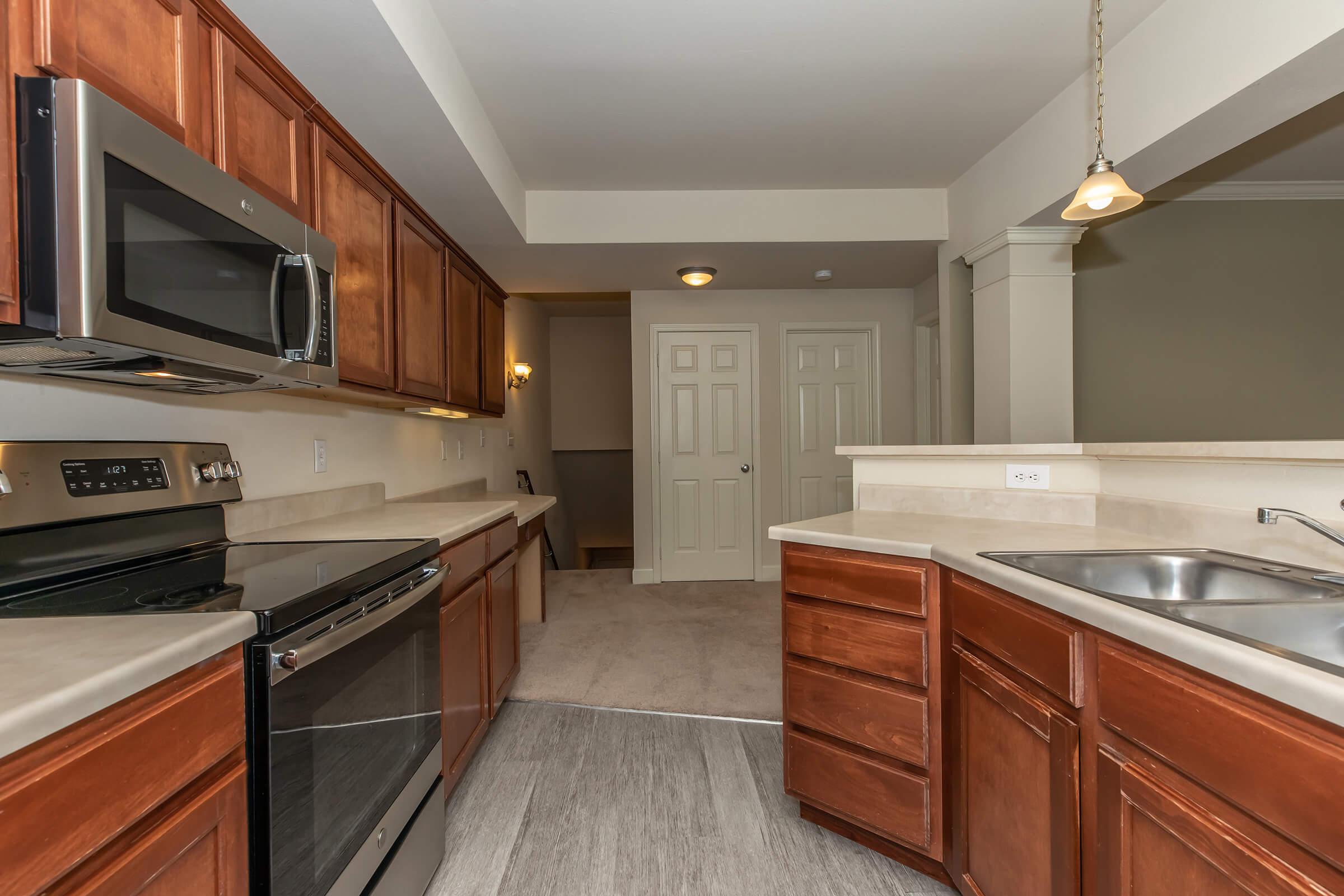 a large kitchen with stainless steel appliances and wooden cabinets