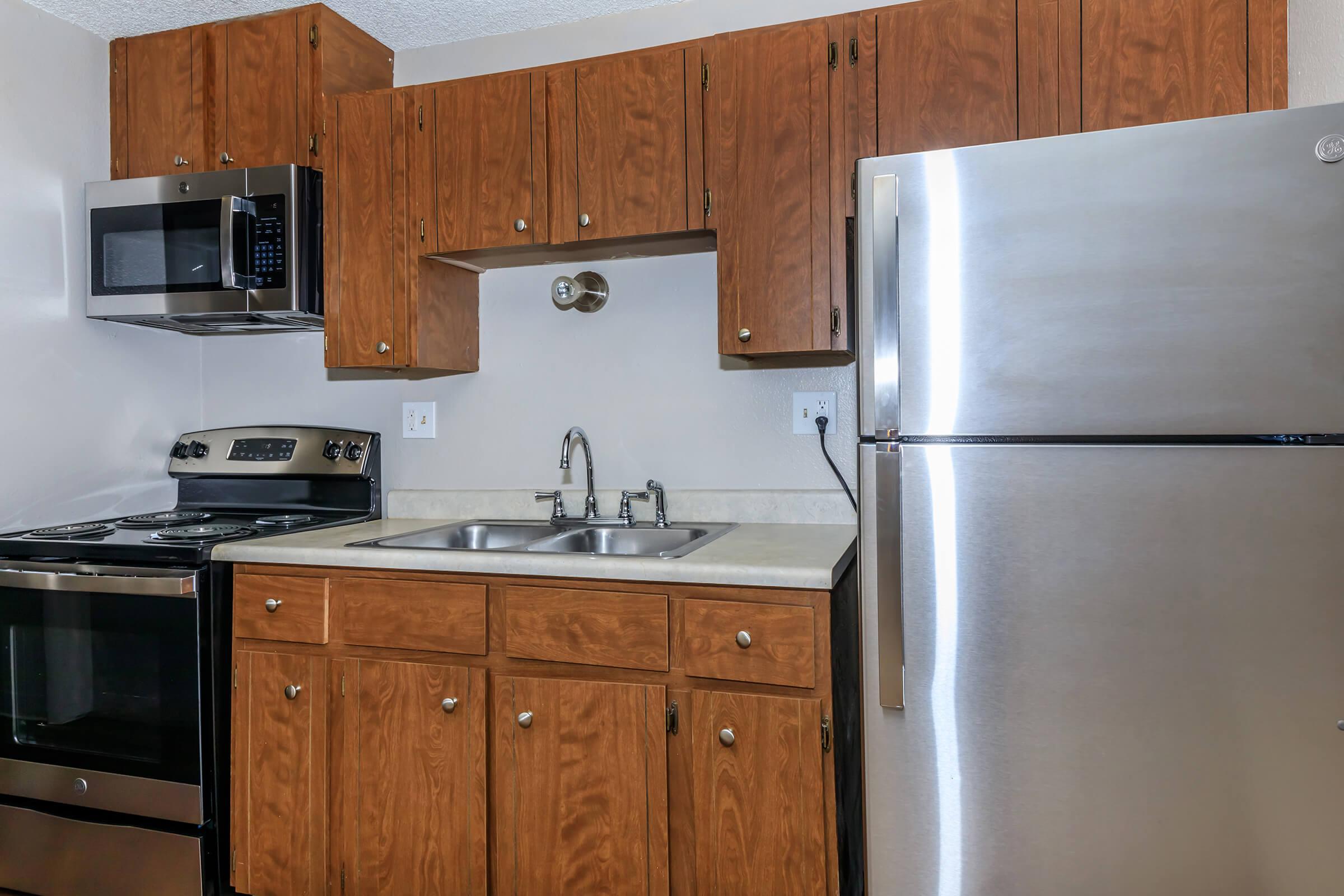 a kitchen with stainless steel appliances and wooden cabinets