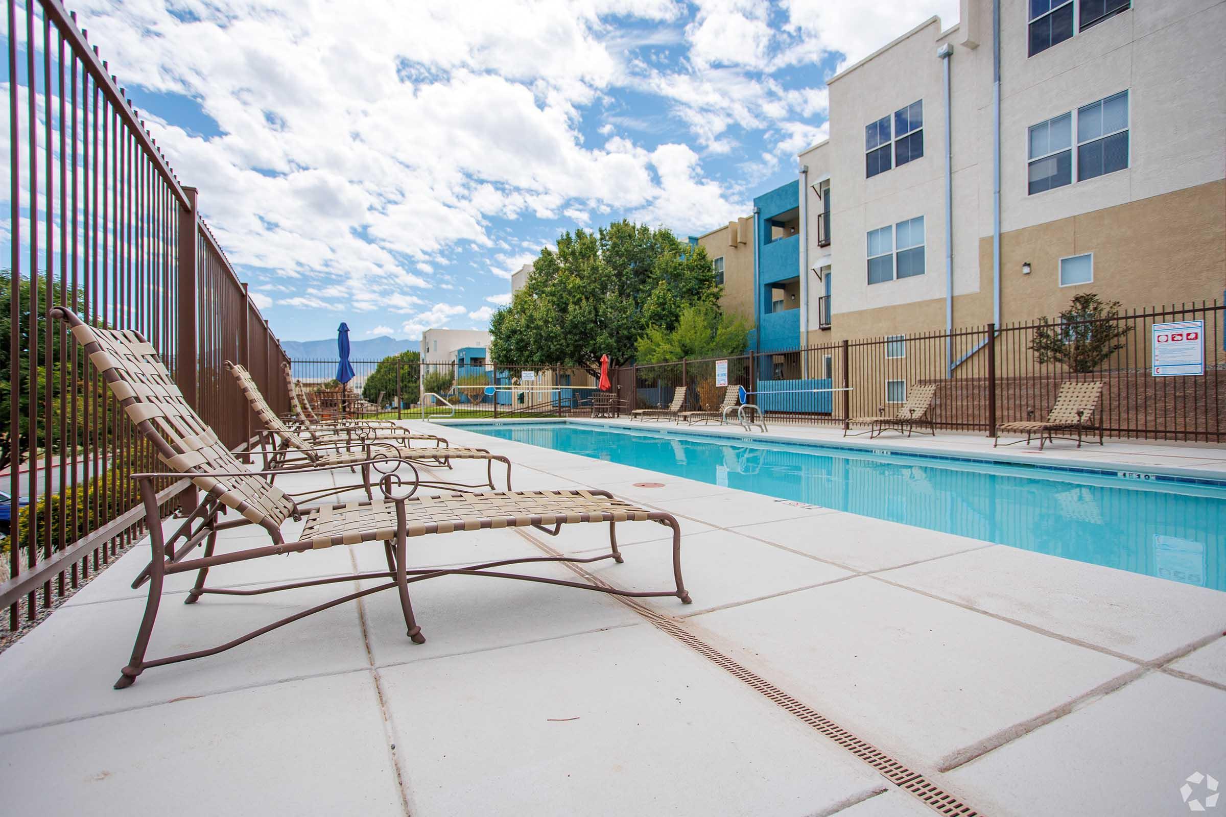 a building with a pool in front of a fence