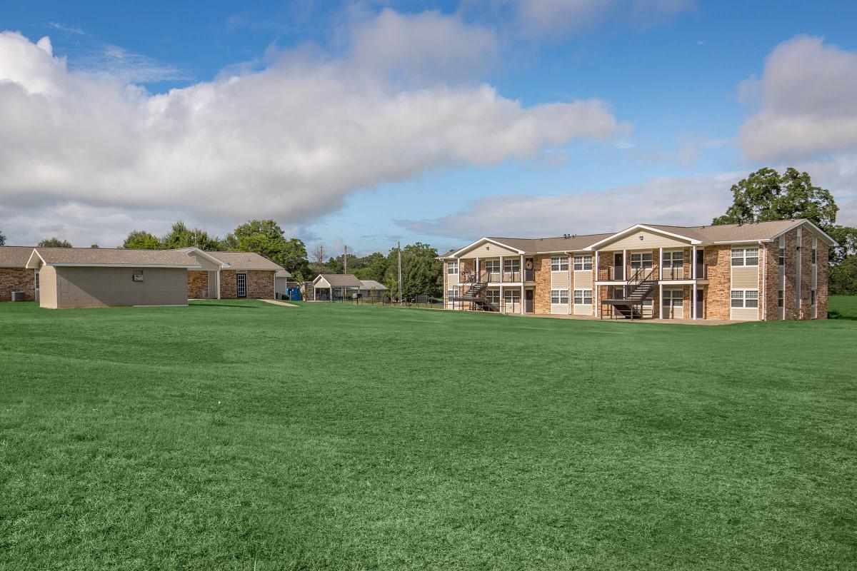 a large green field in front of a house