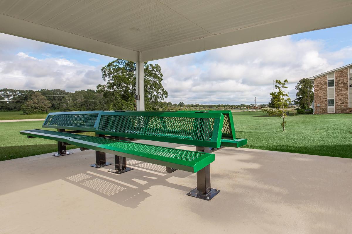 a green bench sitting in front of a building