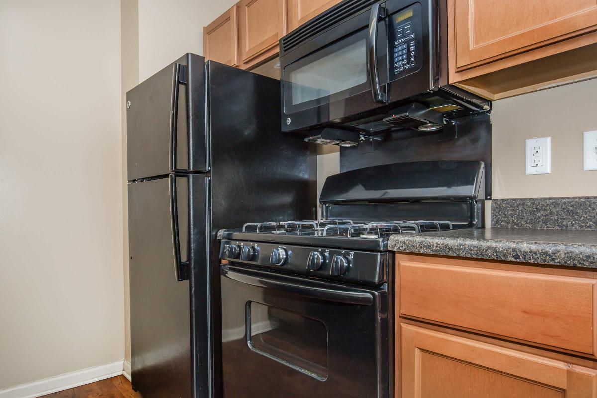 a stove top oven sitting inside of a kitchen with stainless steel appliances