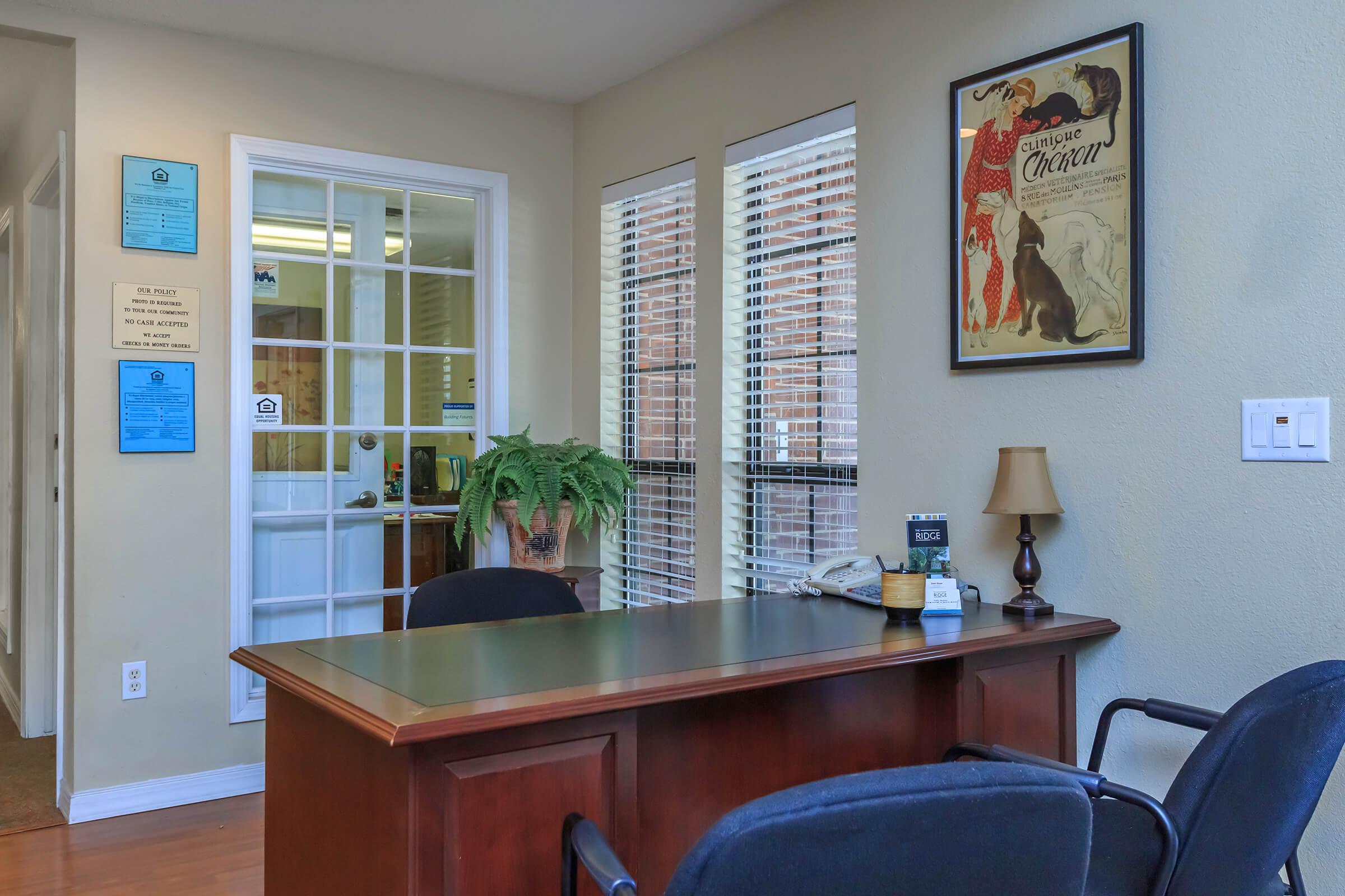 a room with a desk and chair in front of a window