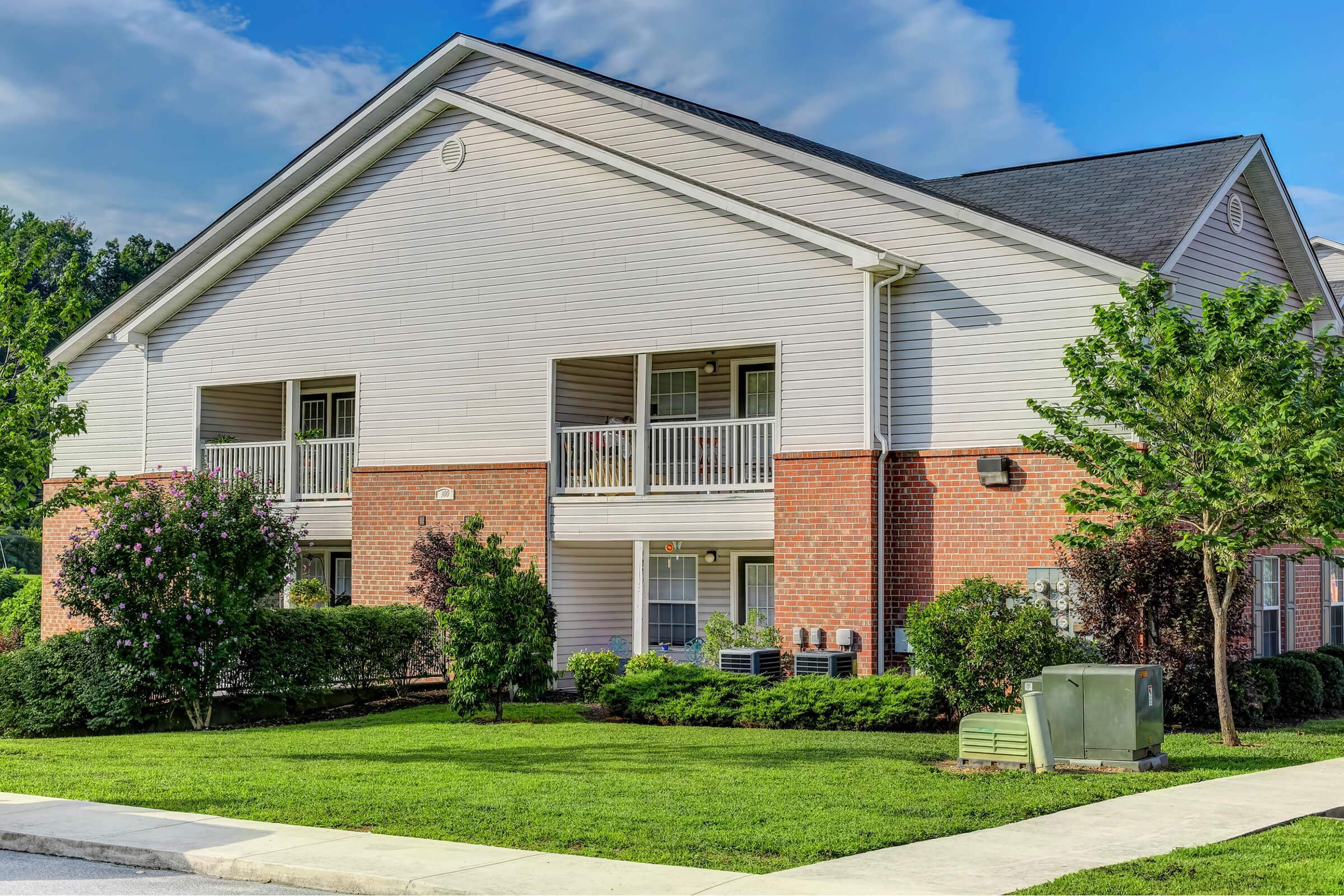 a large brick building with grass in front of a house