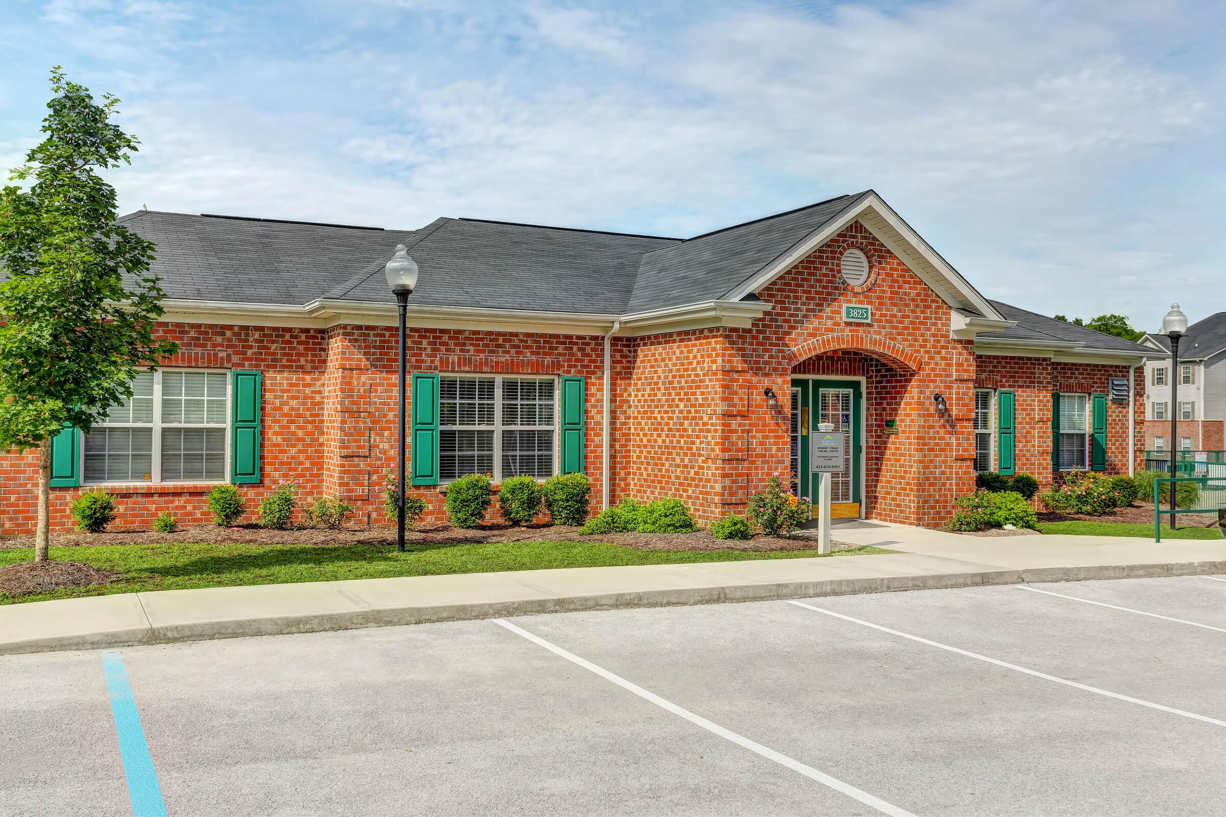 a large brick building with grass in front of a house