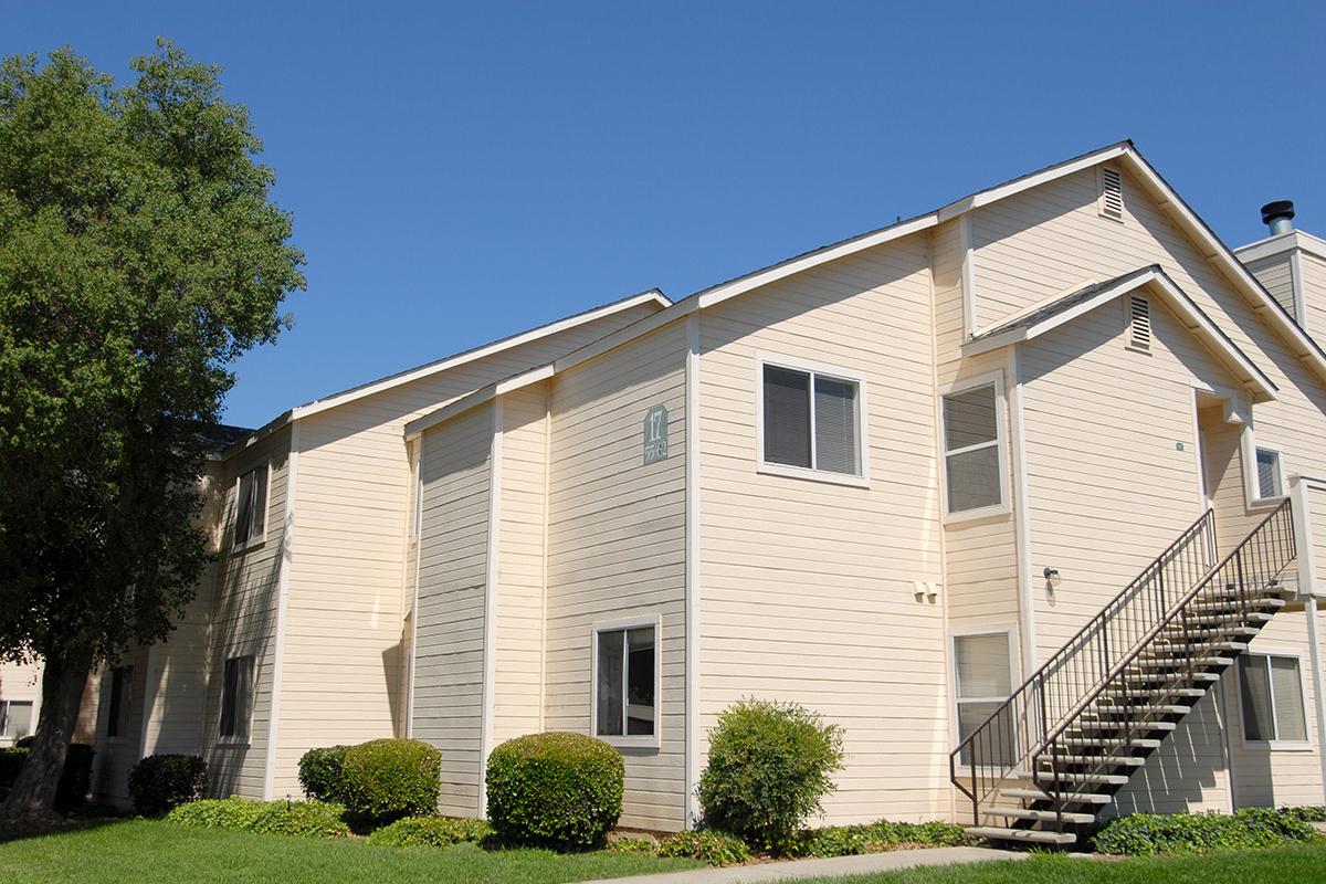 a large brick building with grass in front of a house