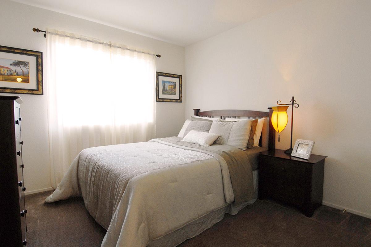 a bedroom with a bed and desk in a hotel room