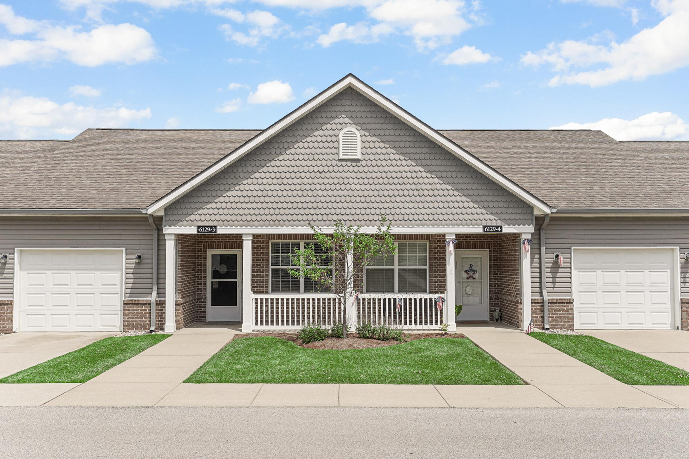 a large brick building with grass in front of a house