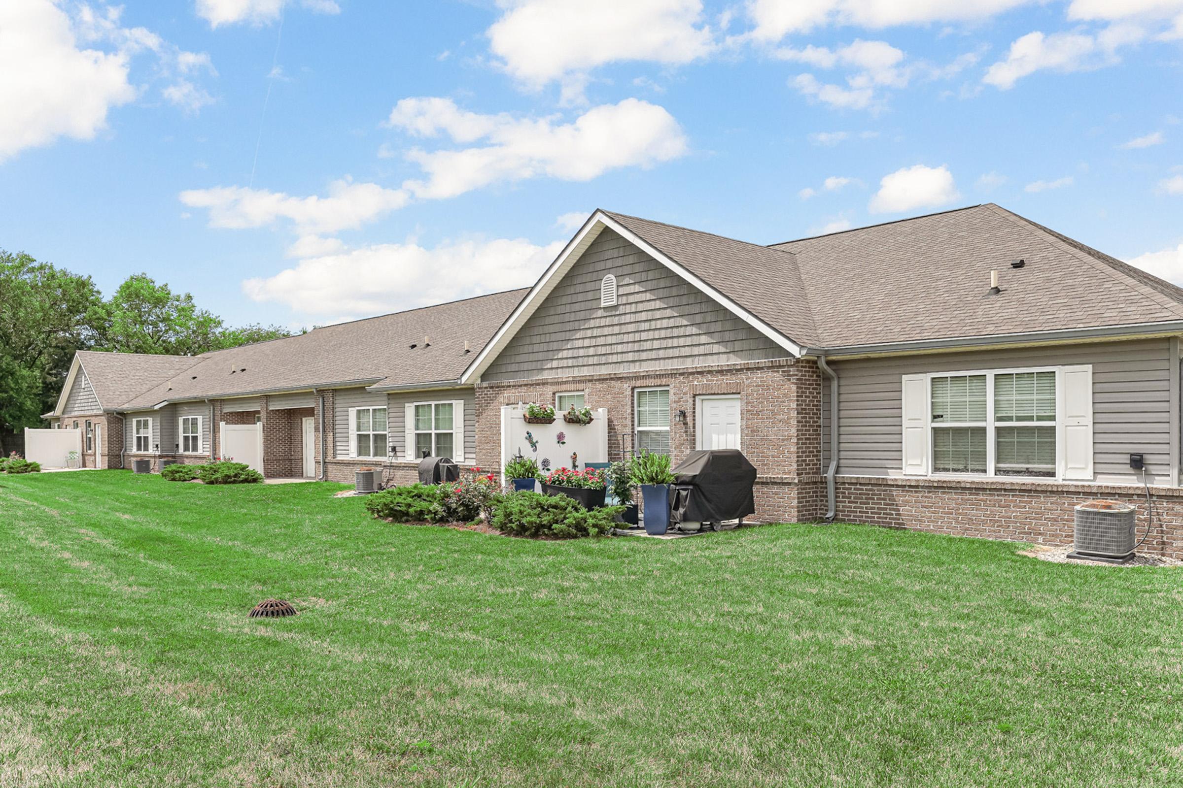 a large green field in front of a house