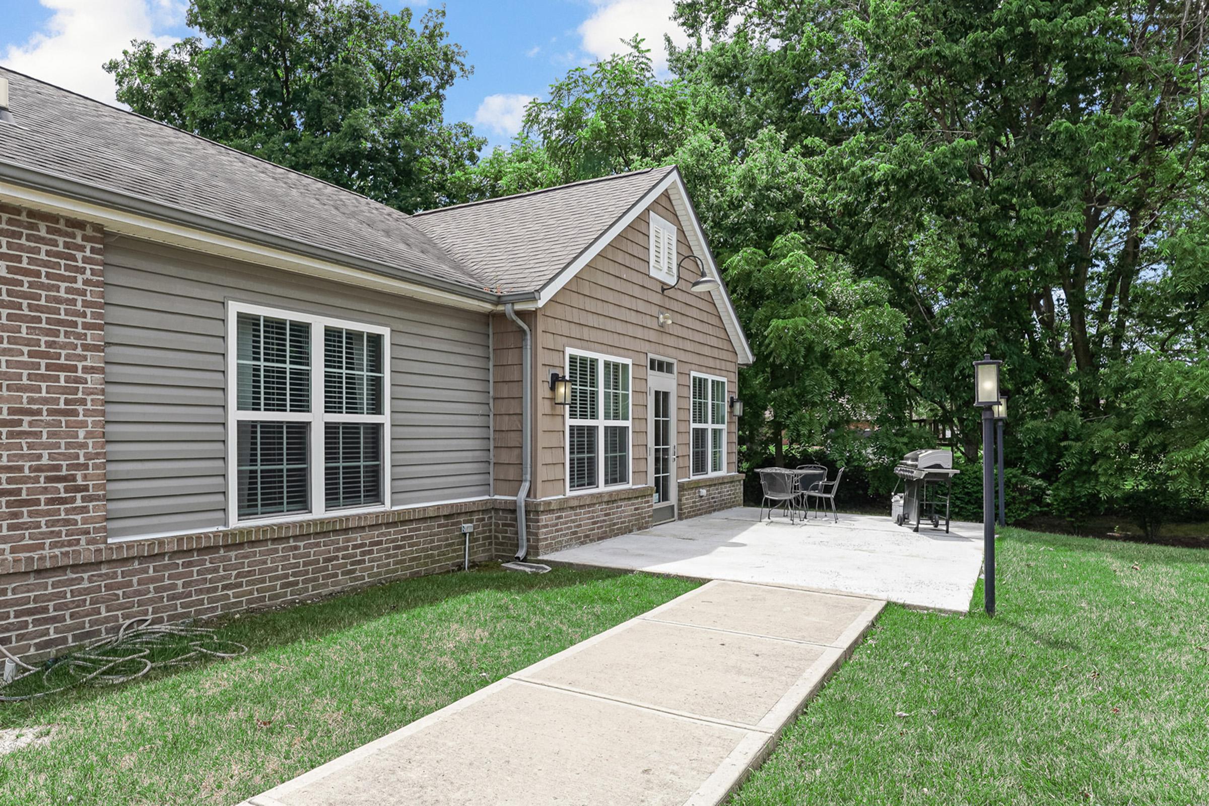 a house with a lawn in front of a brick building