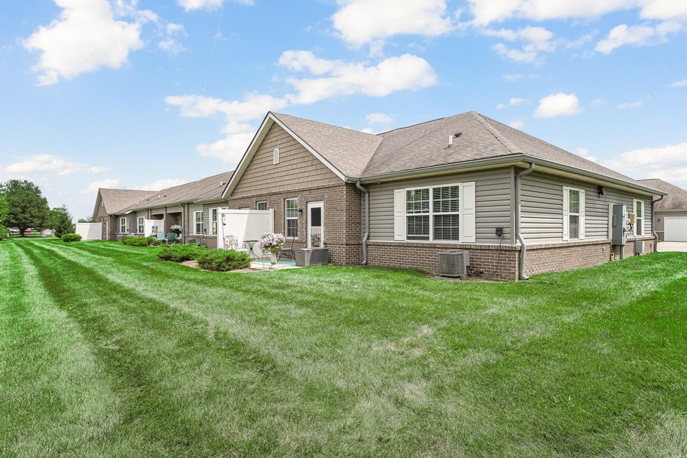 a large green field in front of a house