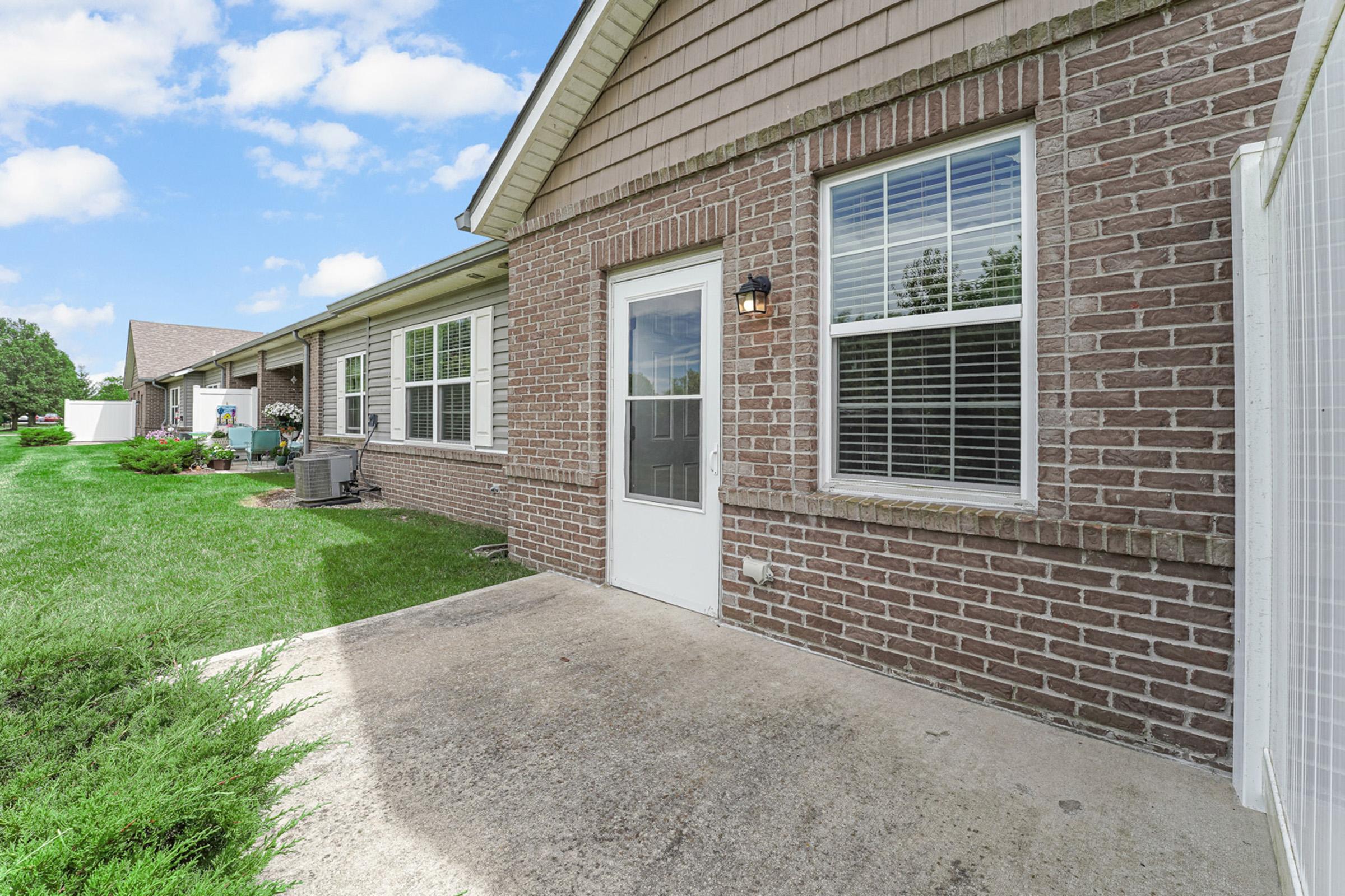 a large brick building with grass in front of a house