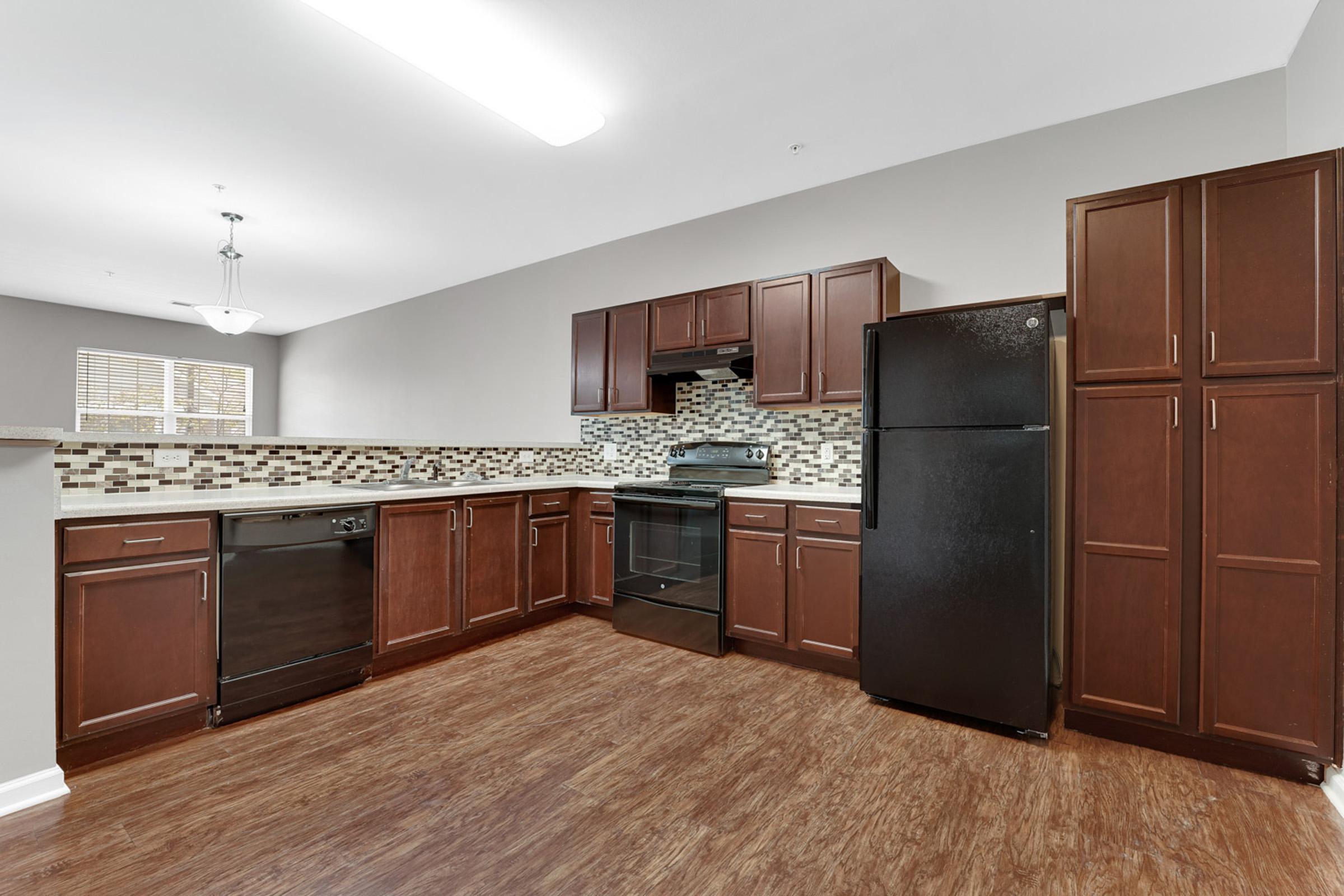 a large kitchen with stainless steel appliances and wooden cabinets