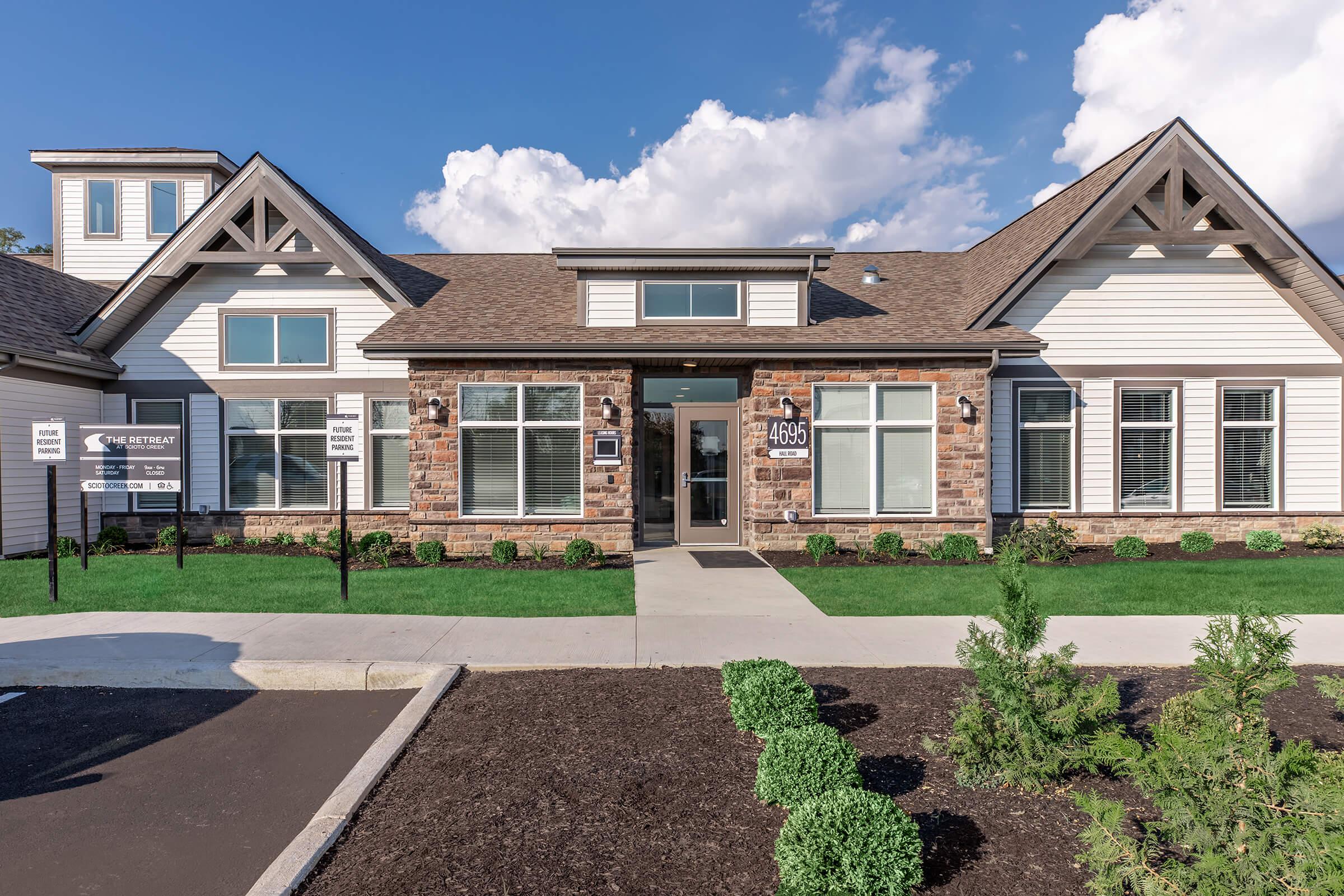 a large brick building with grass in front of a house