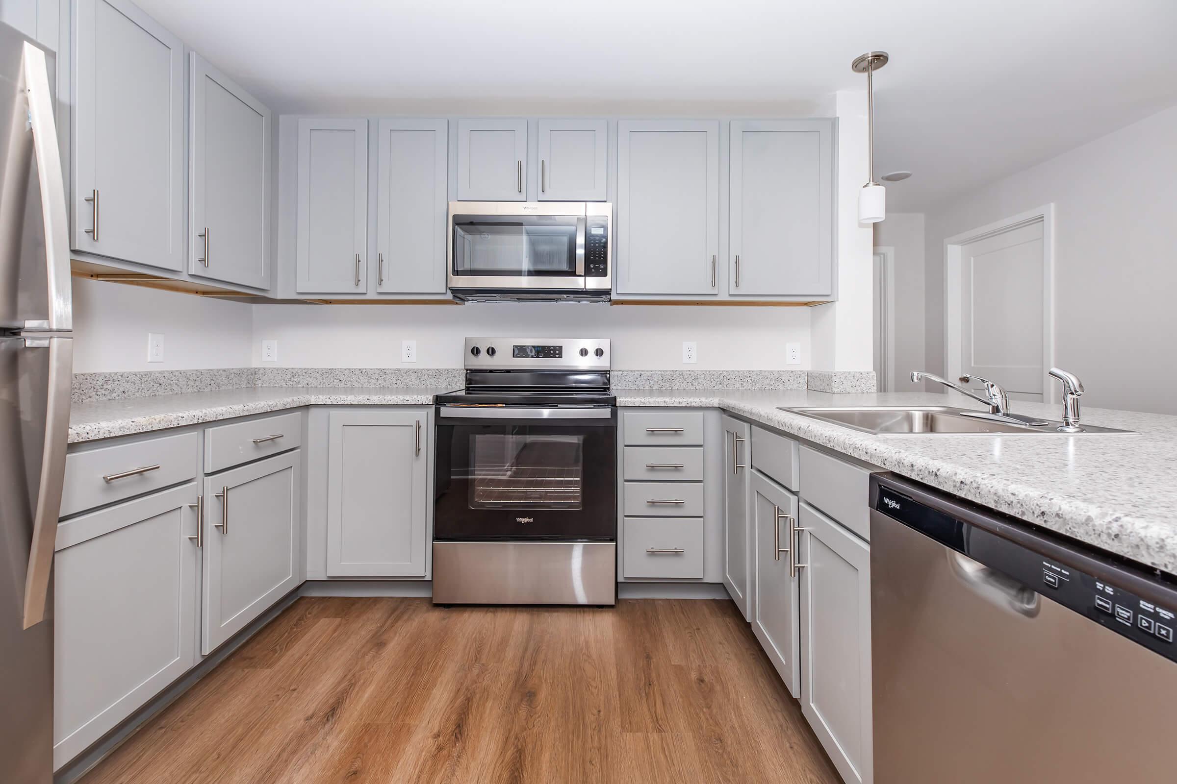 a large kitchen with stainless steel appliances and wooden cabinets