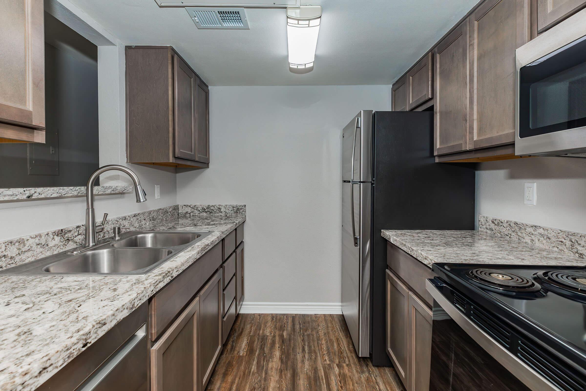 a large kitchen with stainless steel appliances and wooden cabinets