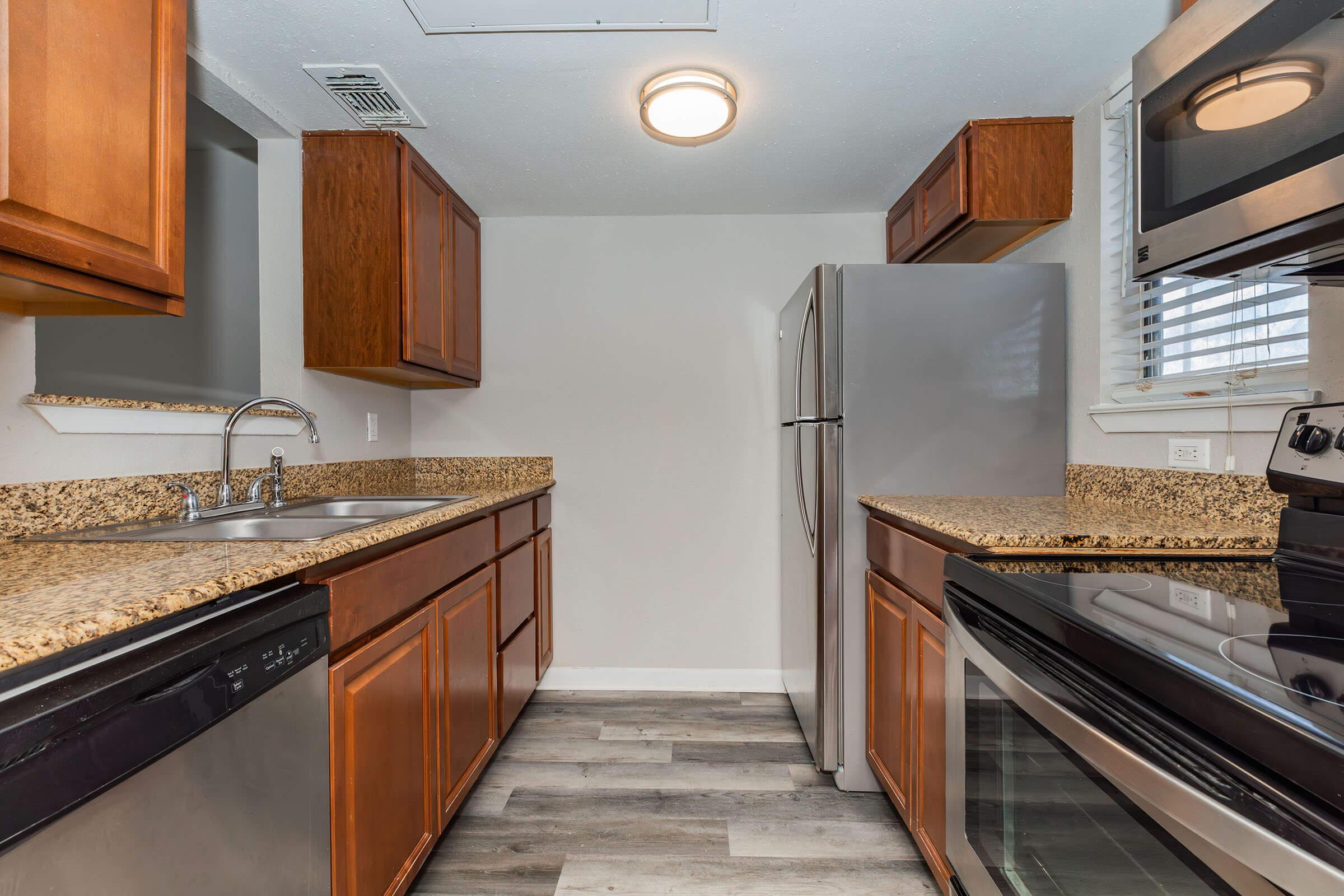 a large kitchen with stainless steel appliances and wooden cabinets