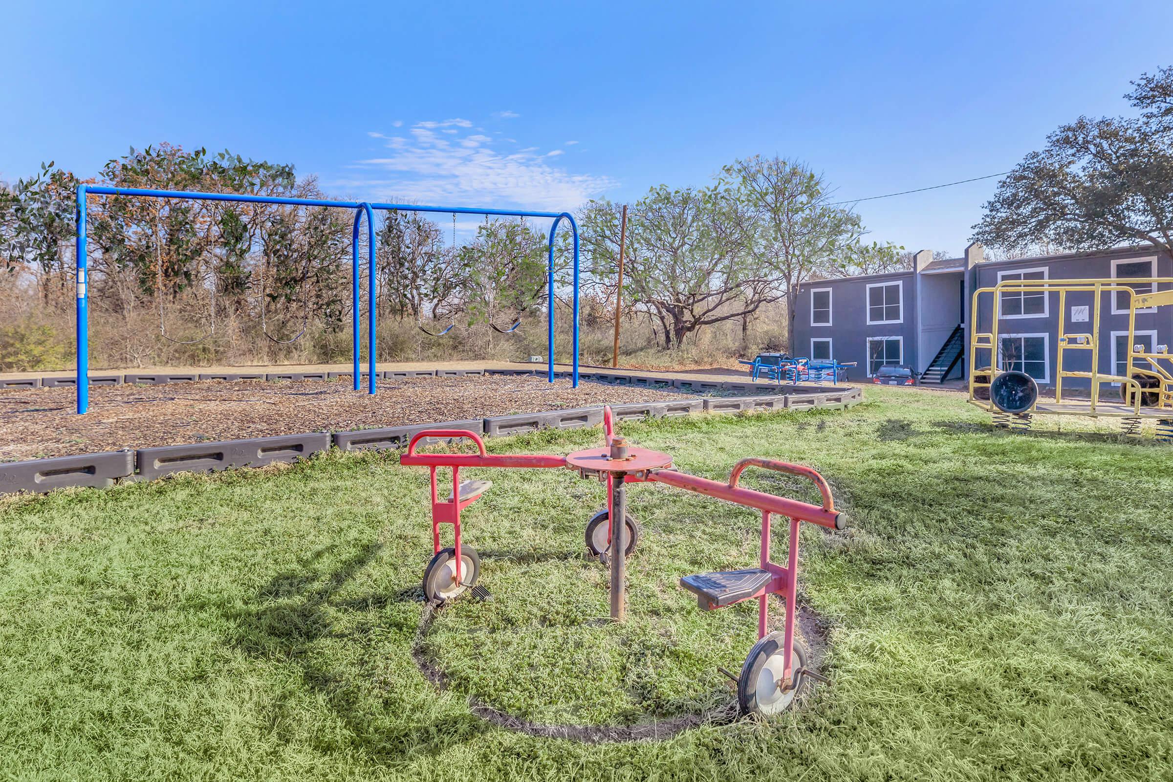 a little boy that is standing in the grass near a fence