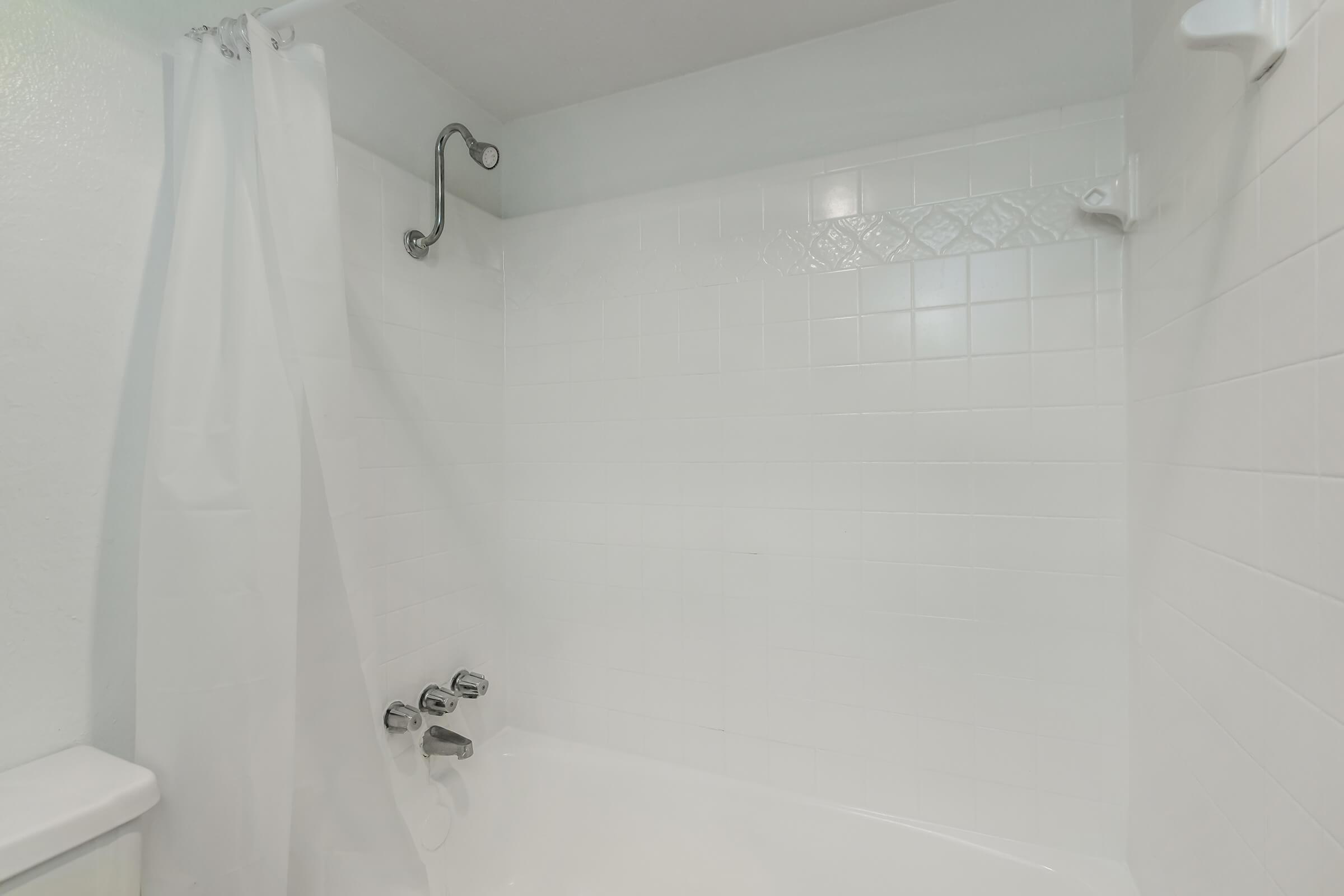 a room with a sink and a white tub sitting next to a shower