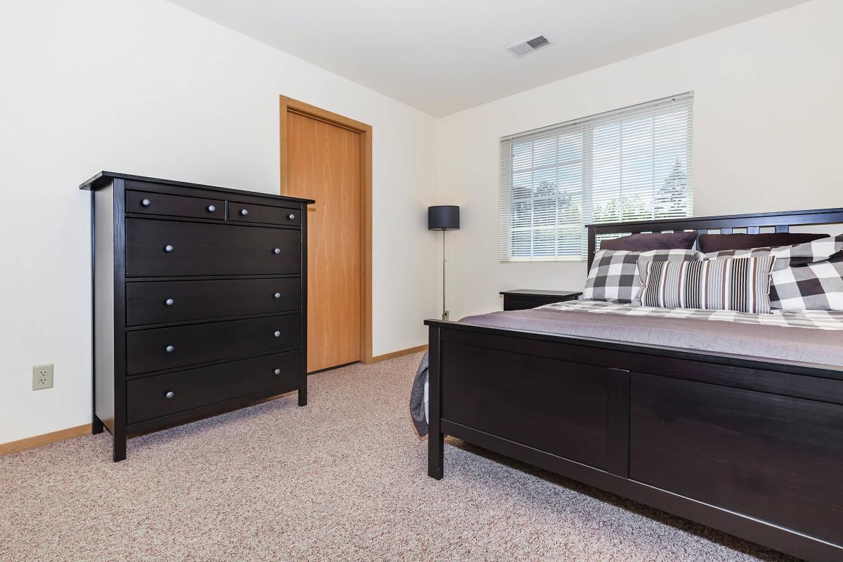 a bedroom with a bed and desk in a room