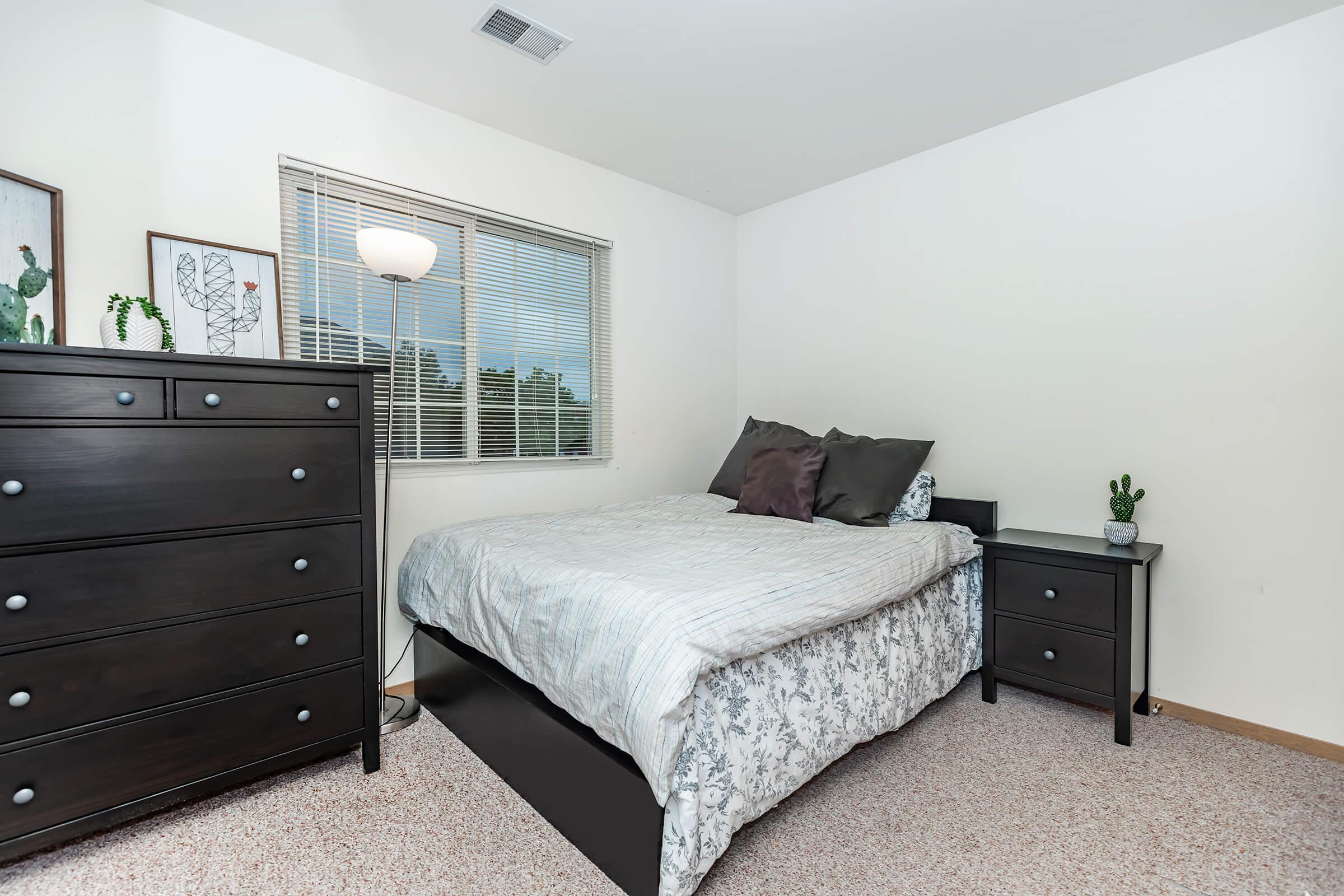 a bedroom with a bed and desk in a room