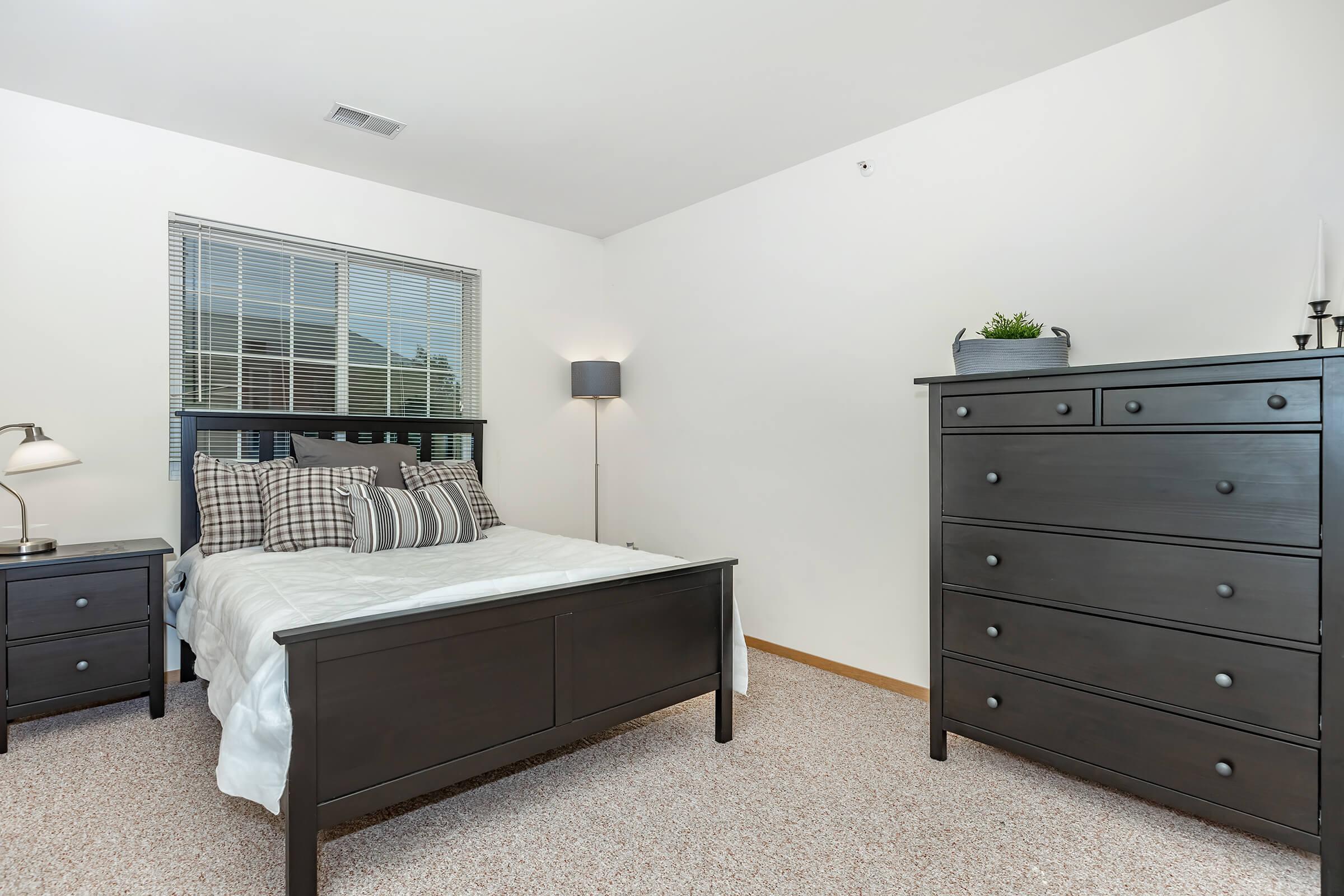 a bedroom with a bed and desk in a small room