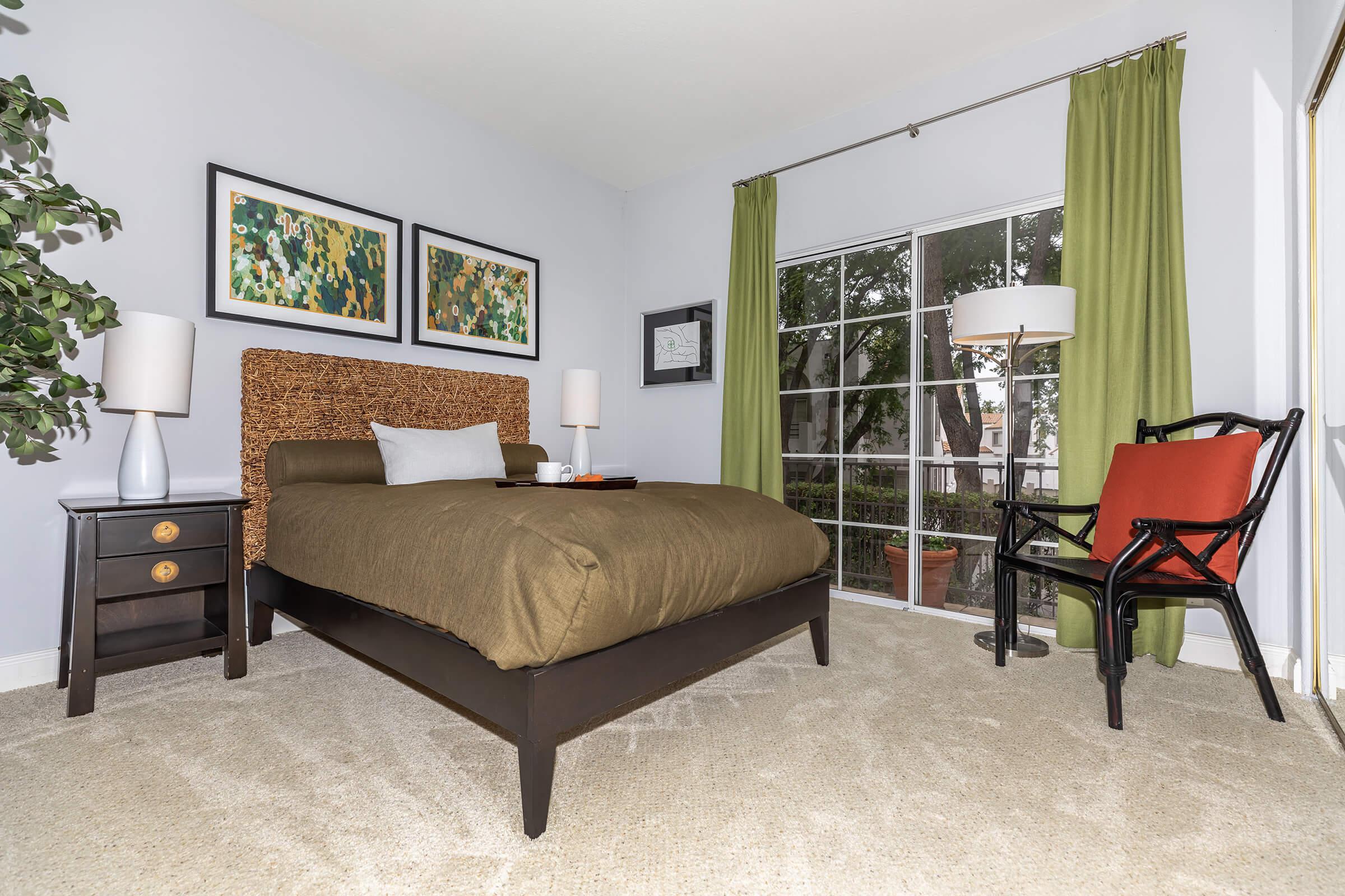 a bedroom with a bed and a chair in a room