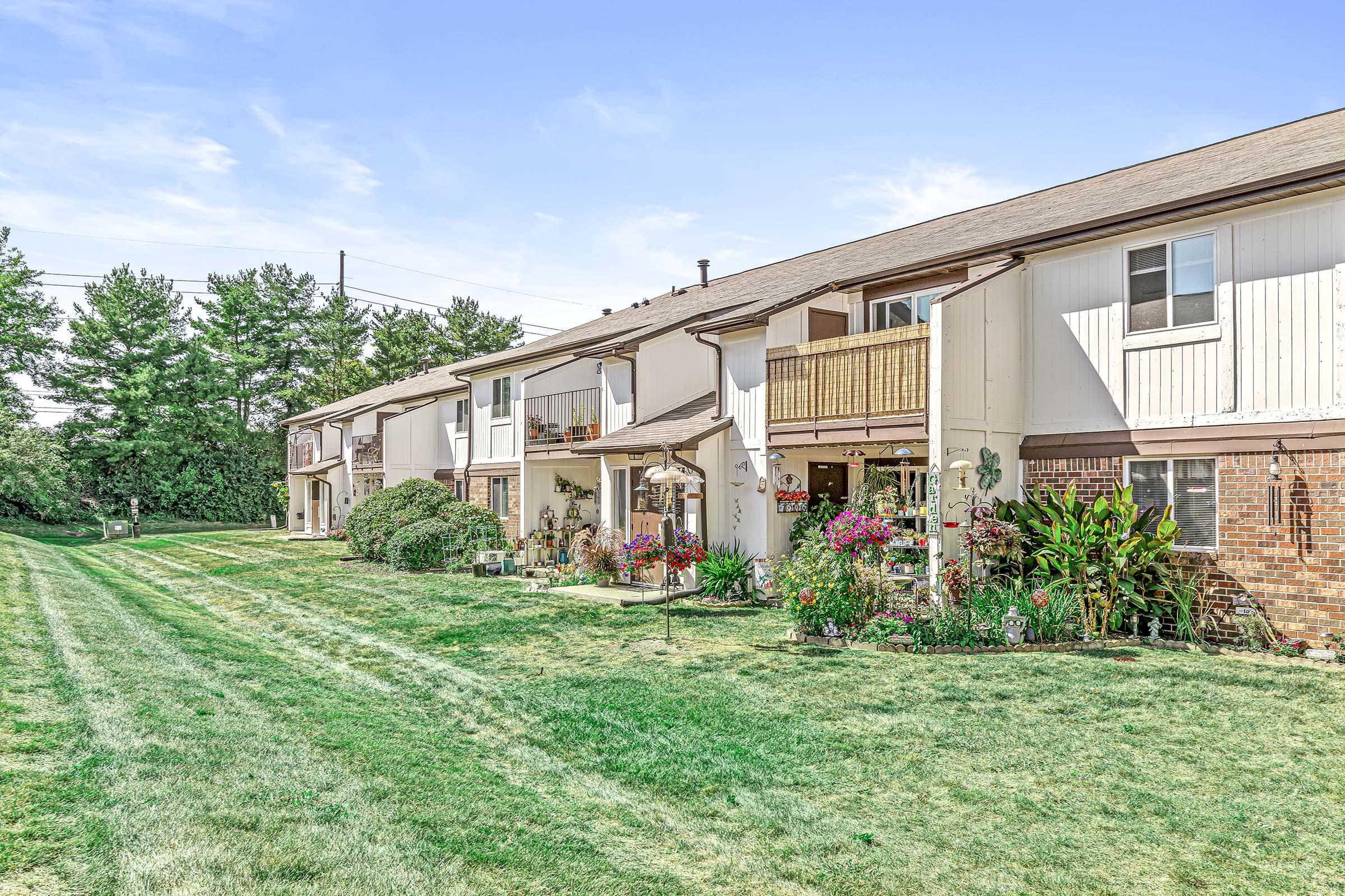 a large brick building with grass in front of a house