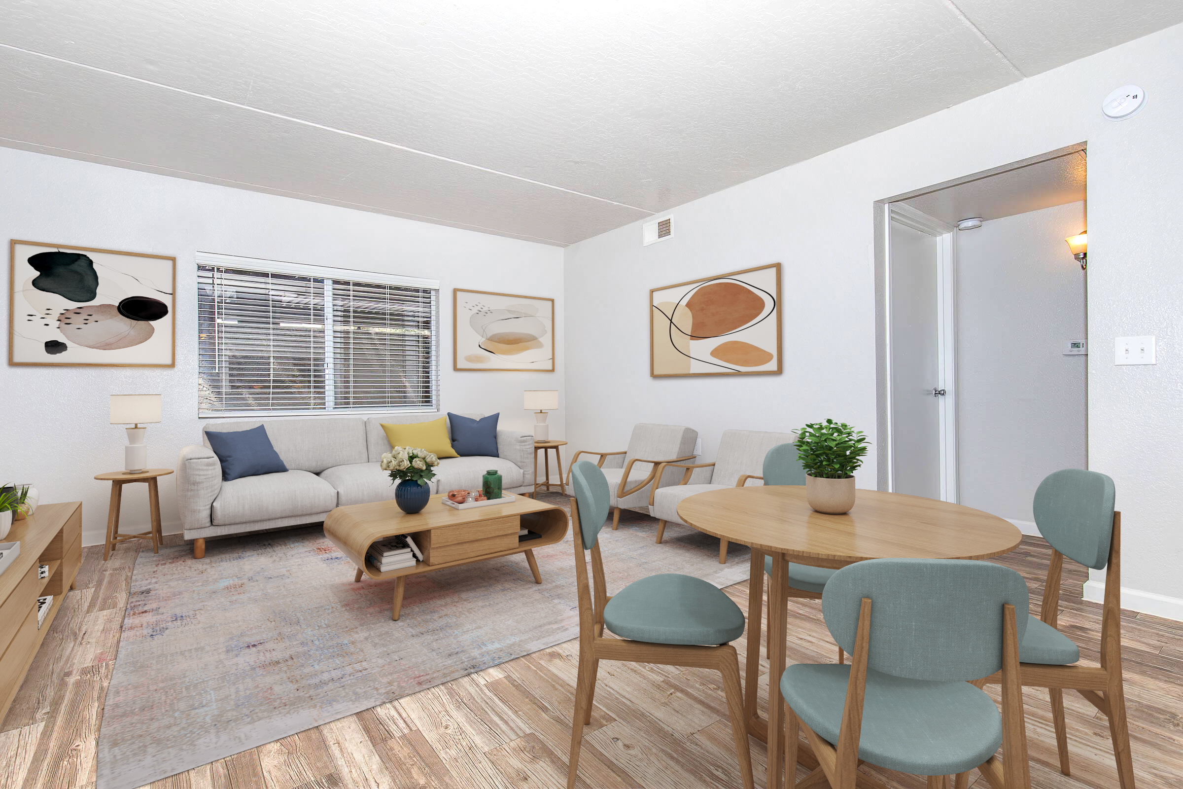 A modern living room featuring a light-colored couch with cushions, a wooden coffee table, and decorative wall art. There are two armchairs, a dining table with four chairs, and a small plant centerpiece. Natural light comes through a window, enhancing the warm, inviting atmosphere of the space.