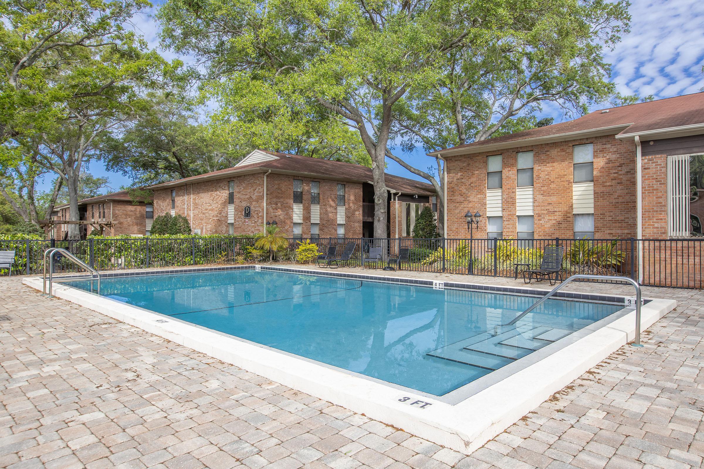 a pool in front of a brick building