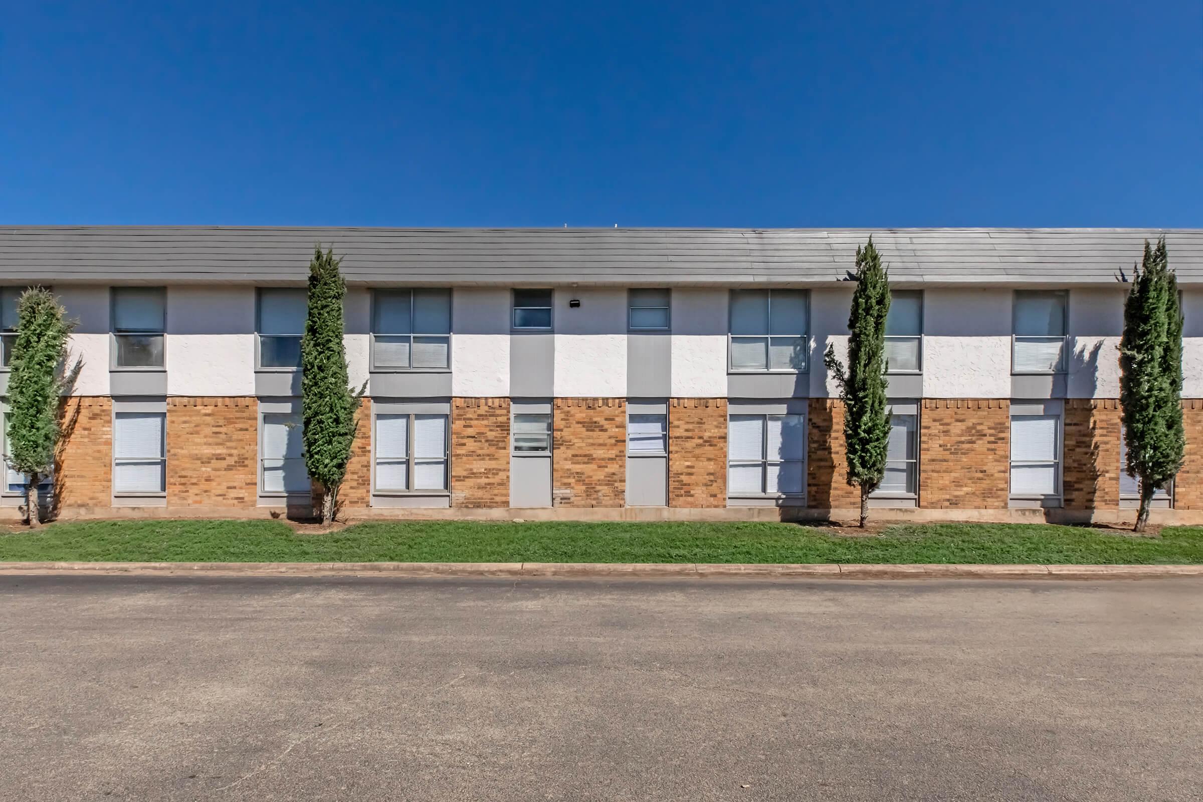 a large brick building with grass in front of a house