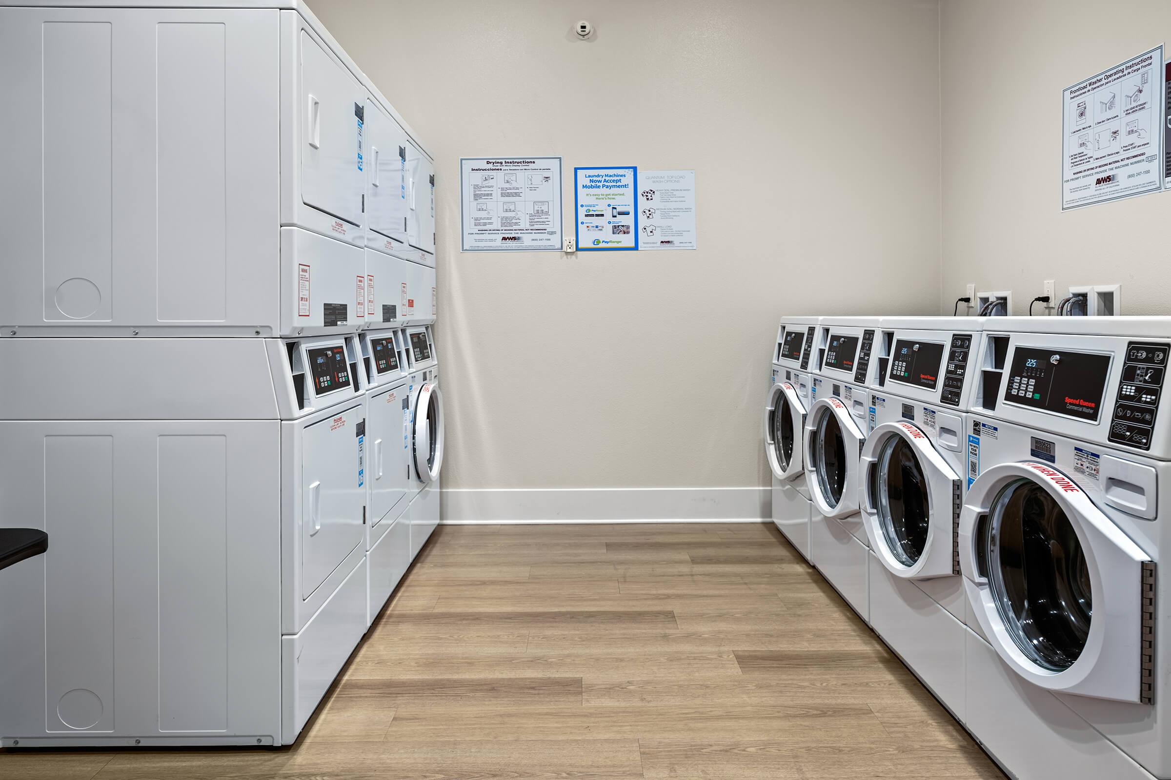 A laundry room featuring rows of washing machines and dryers. 