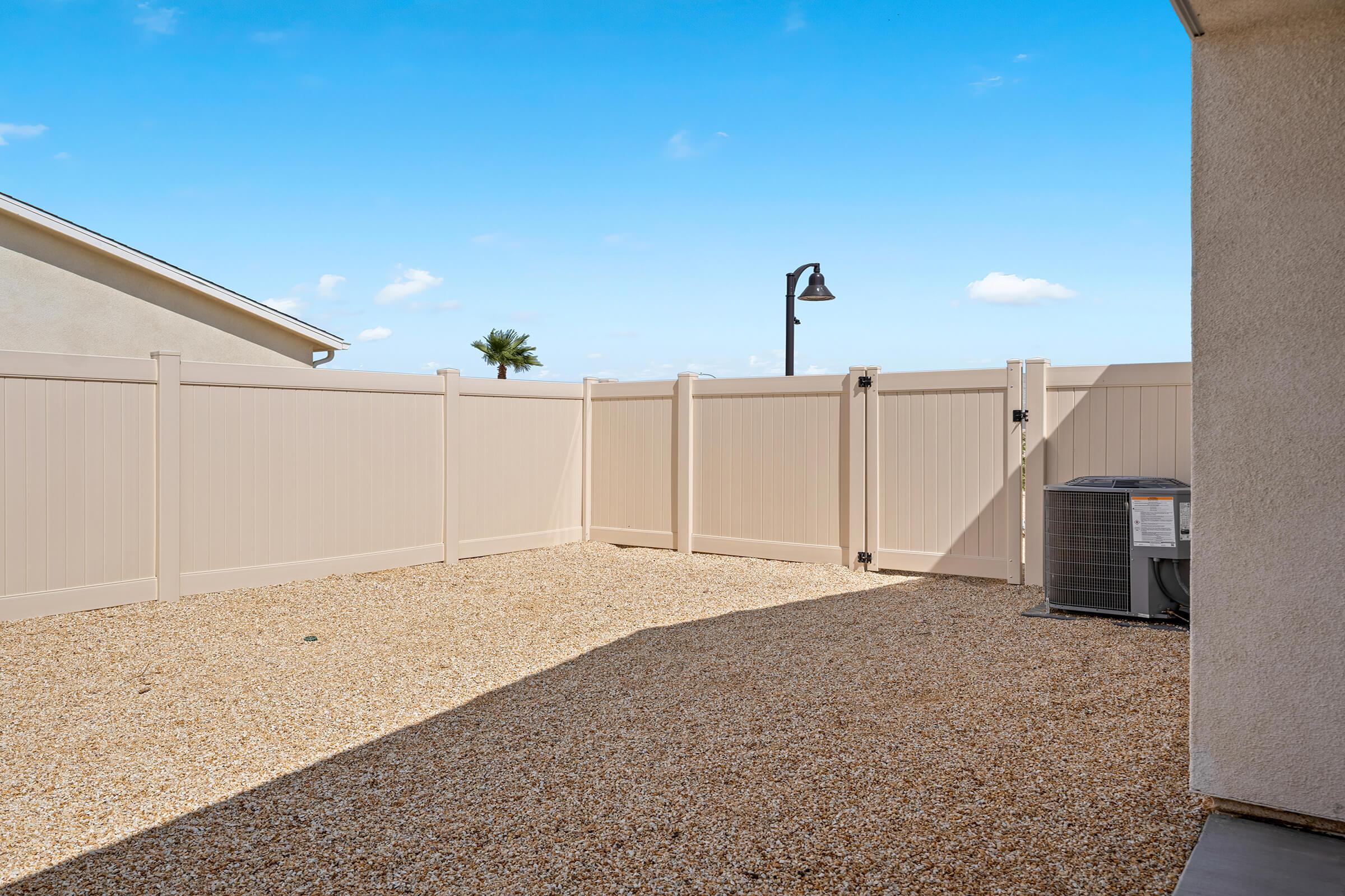 A fenced outdoor area with gravel.