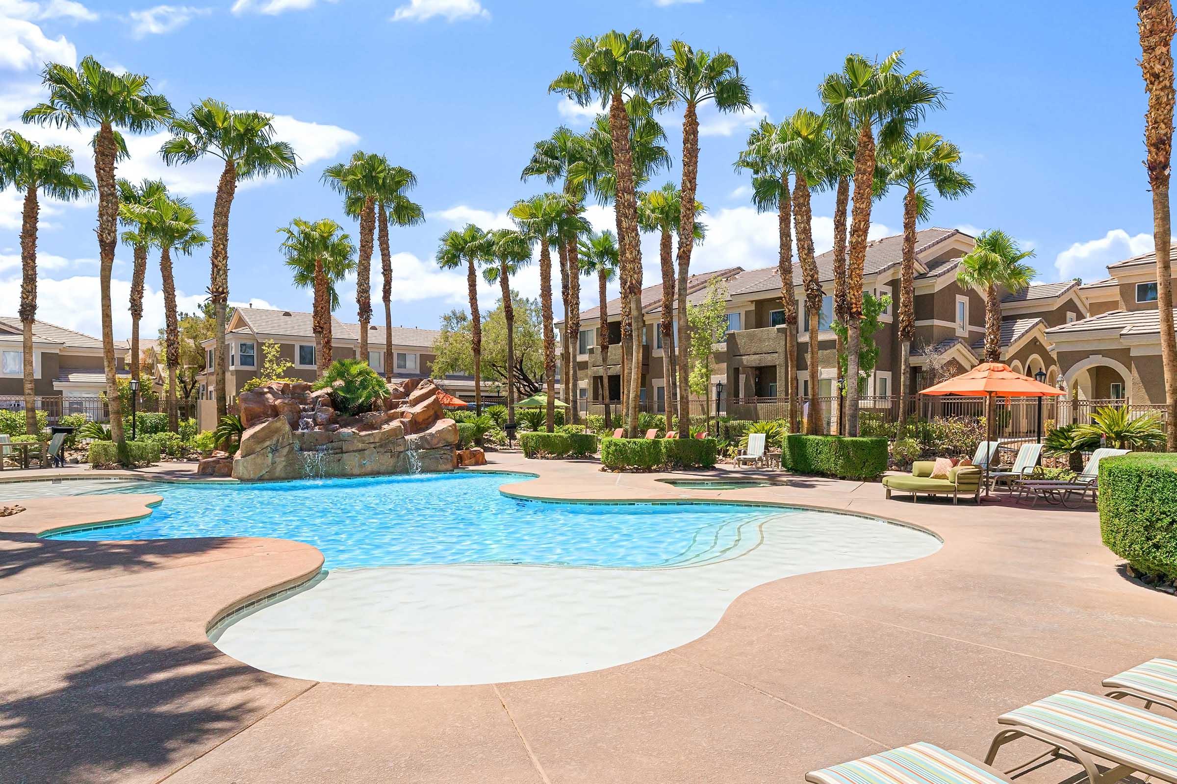 palm trees and water feature next to pool