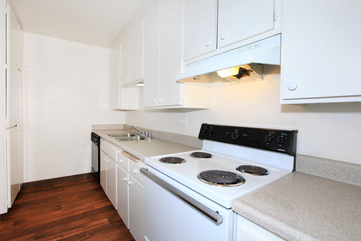 a white stove top oven sitting inside of a kitchen