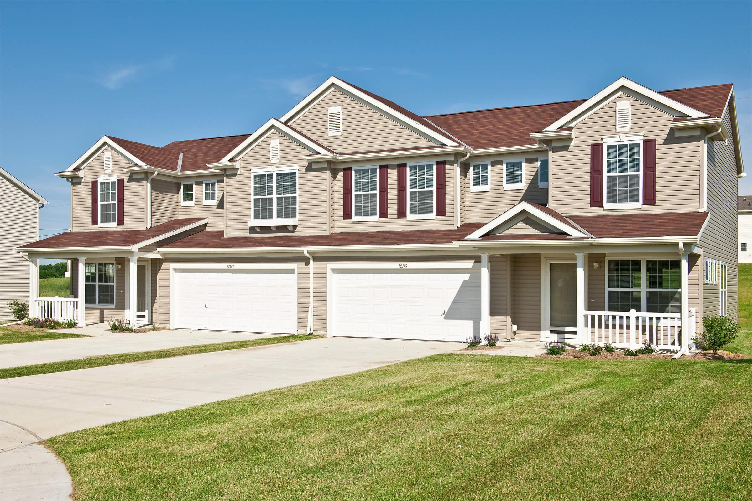 a house with a lawn in front of a brick building