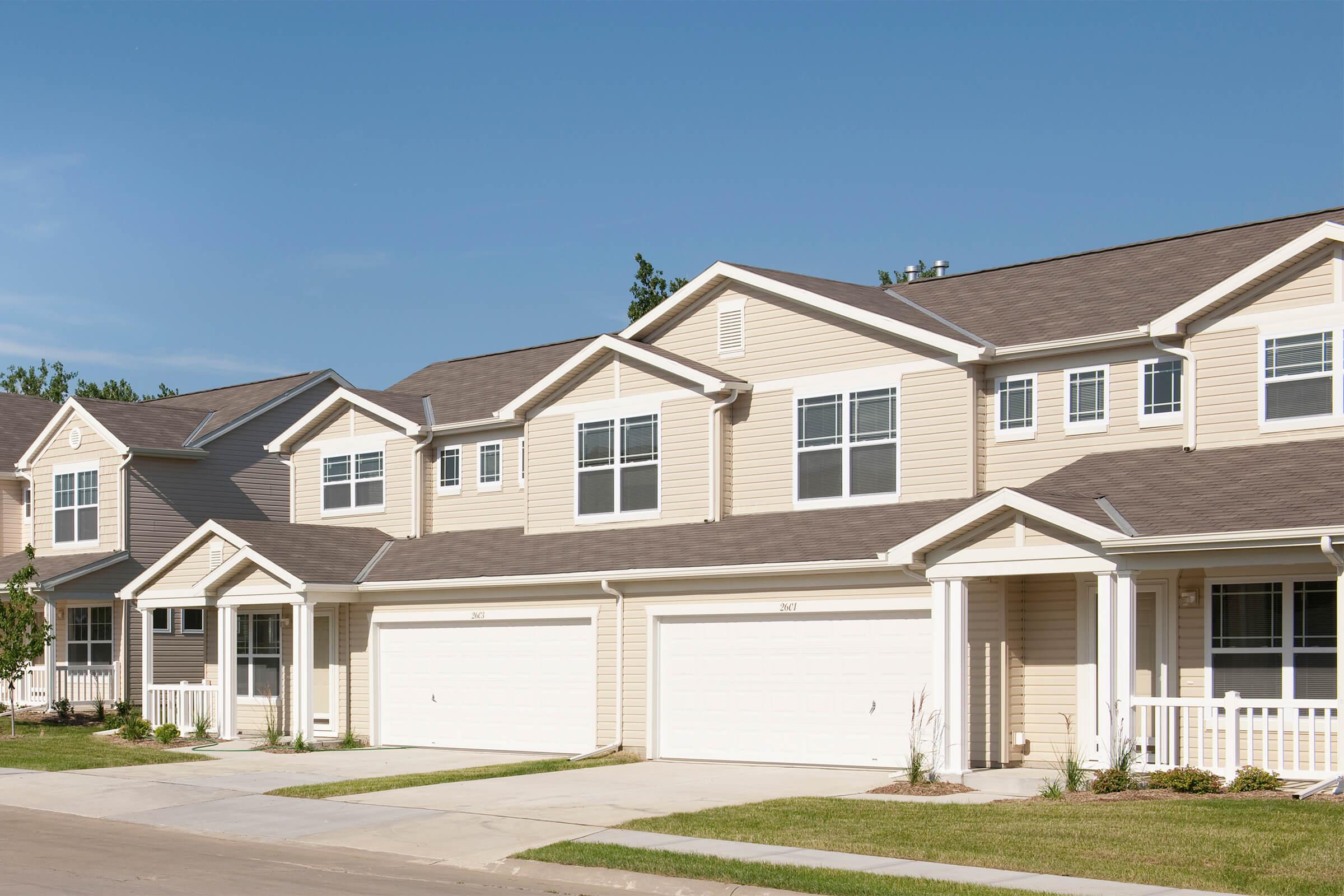 a large brick building with grass in front of a house