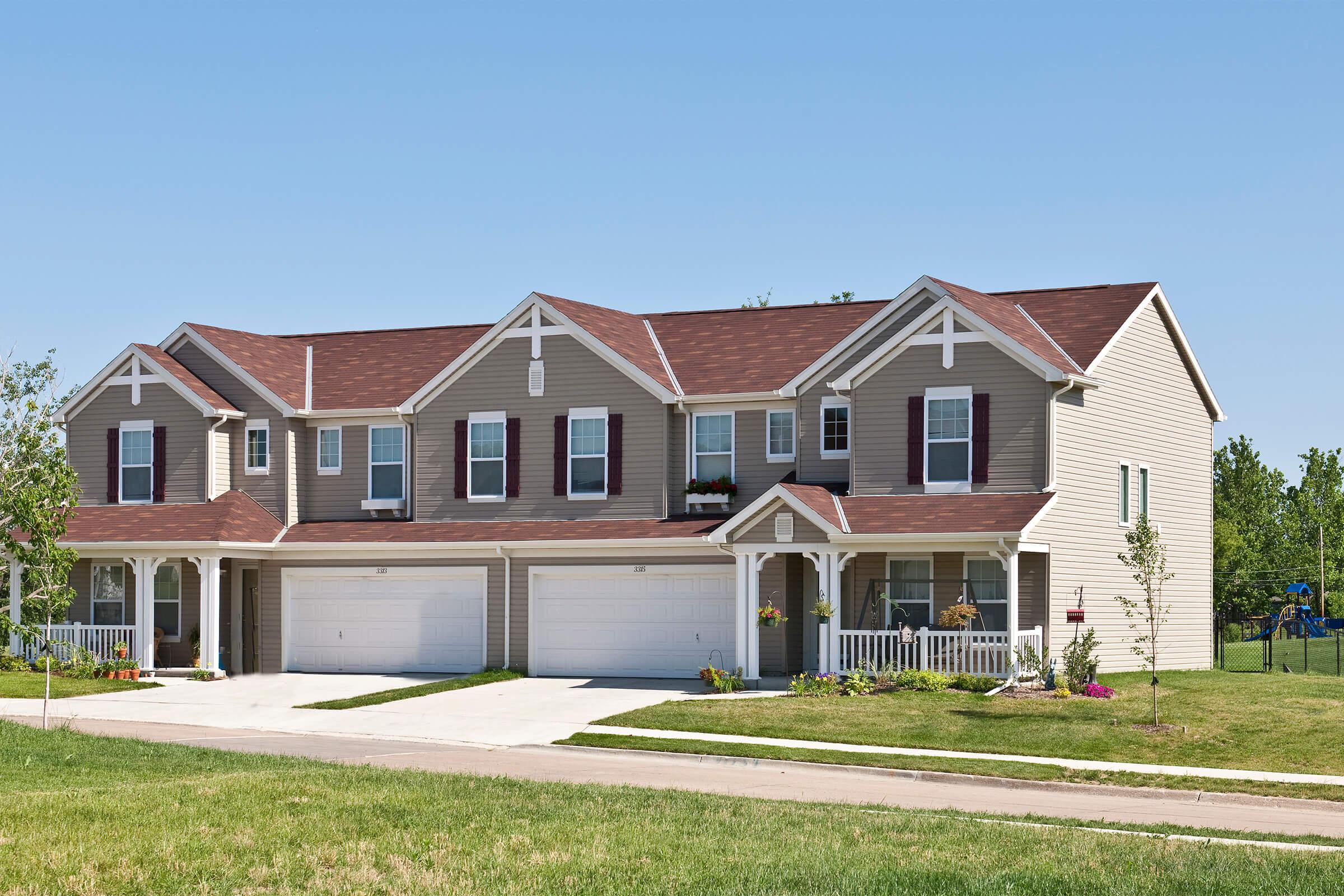 a large brick building with grass in front of a house