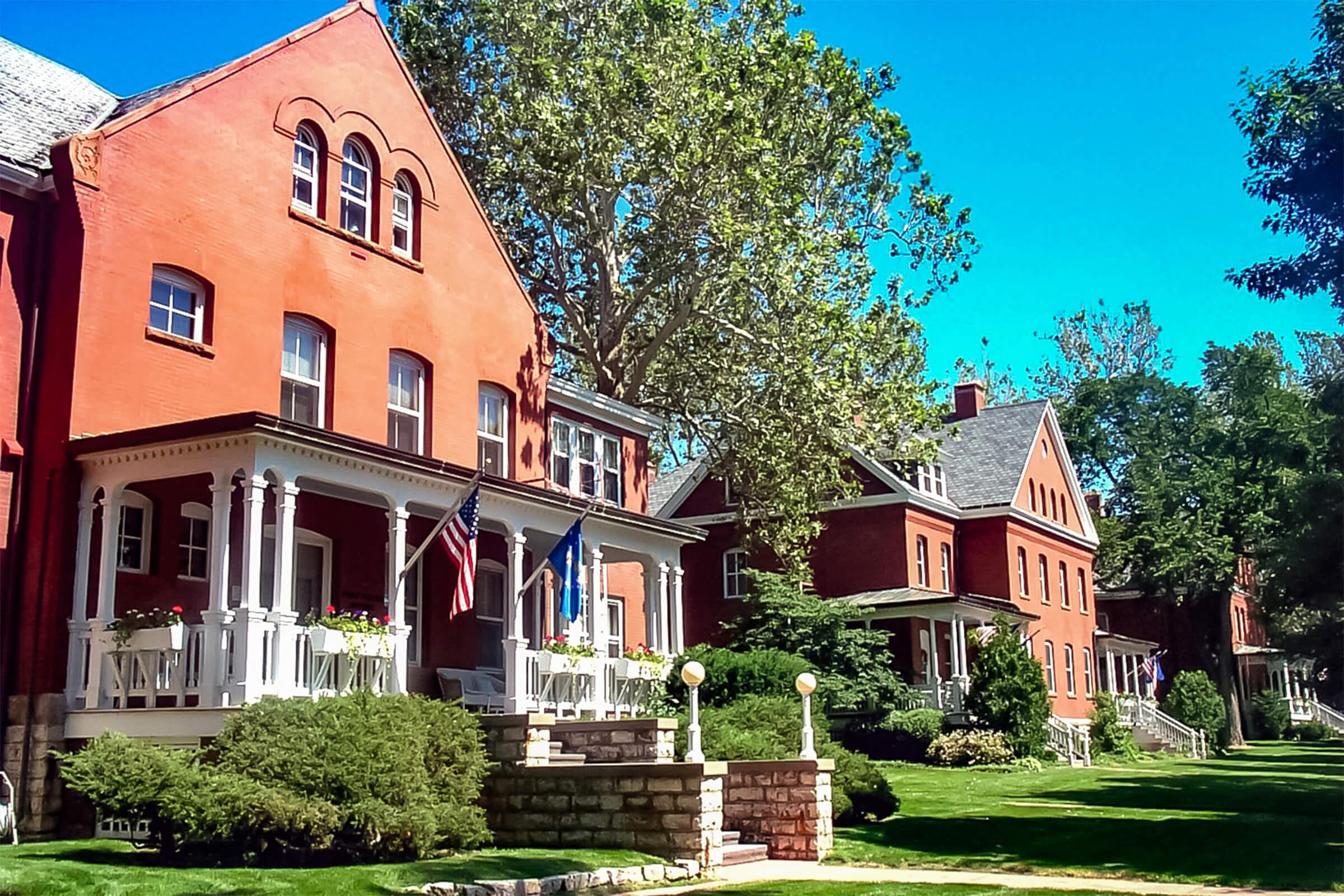 a large brick building with grass in front of a house