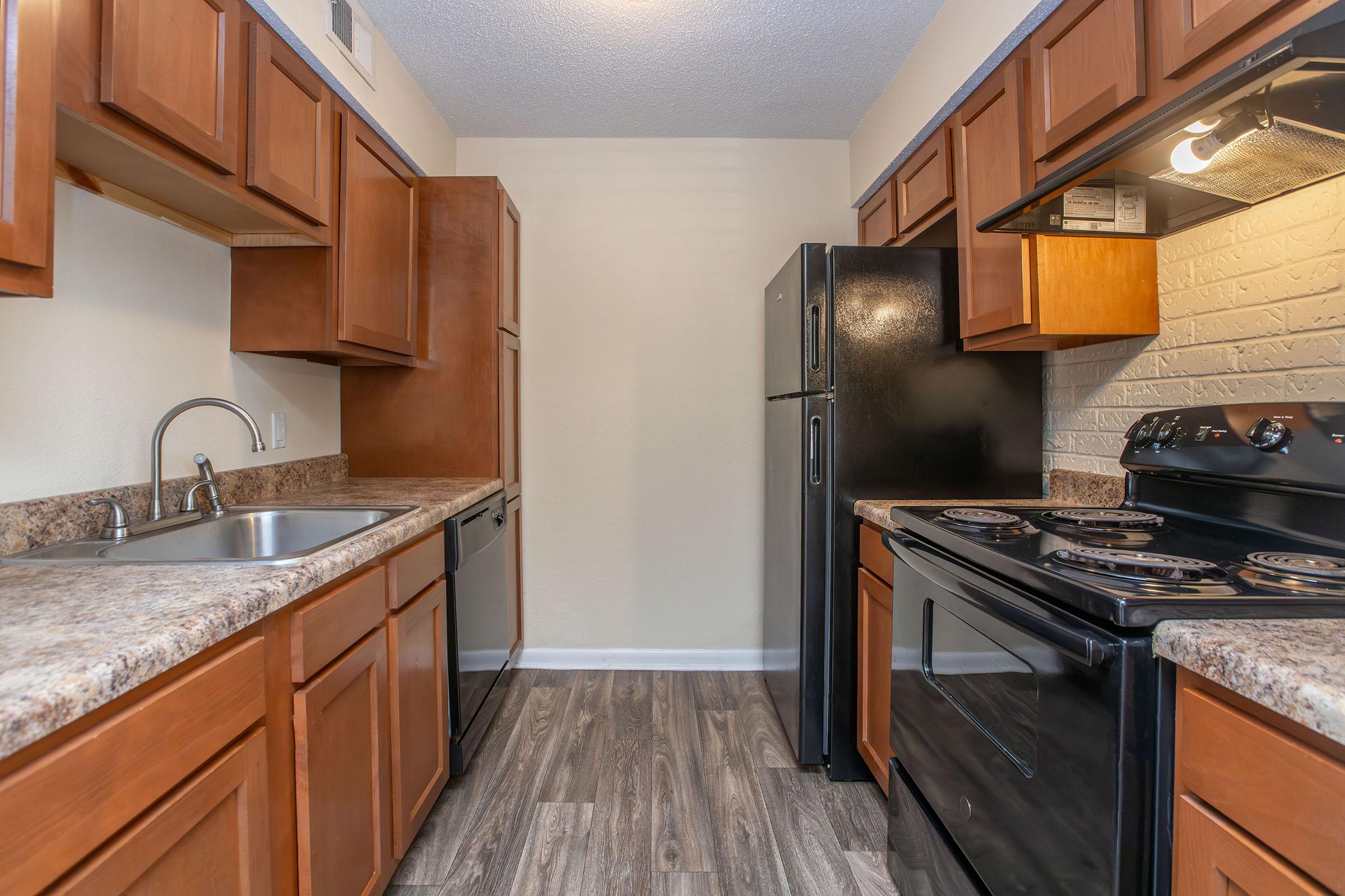 a large kitchen with stainless steel appliances and wooden cabinets