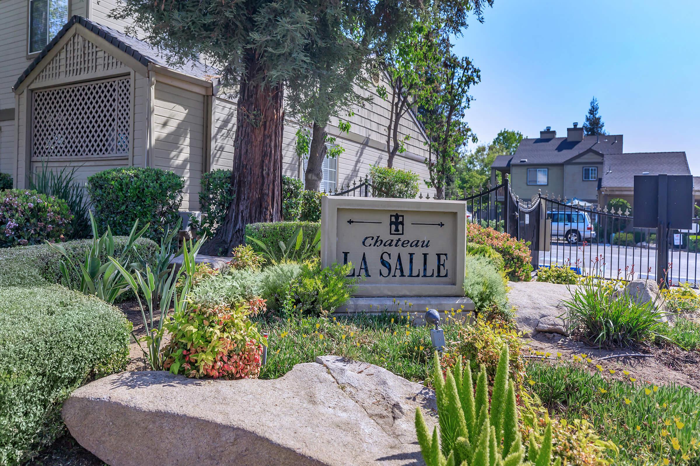 a close up of a flower garden in front of a house